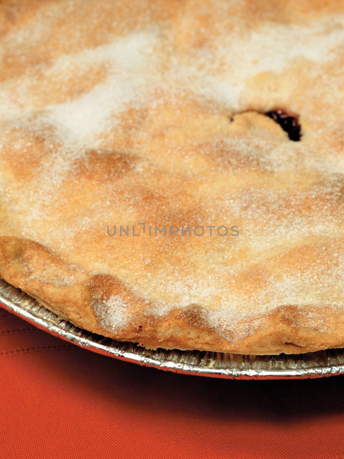 Closeup of hot blueberry, raspberry or even mincemeat pie in tinfoil plate.
