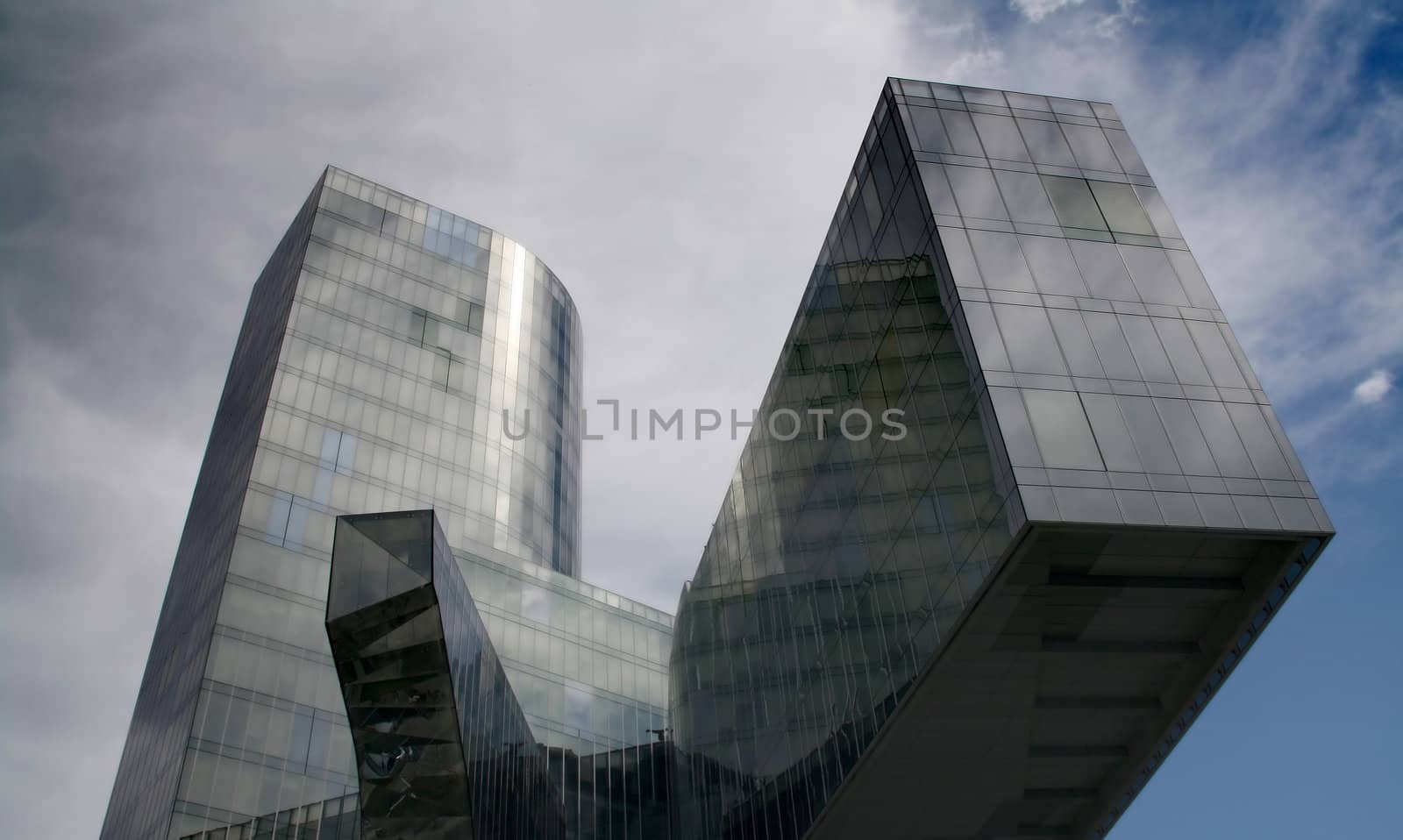Business building, blue glass, clouded sky background