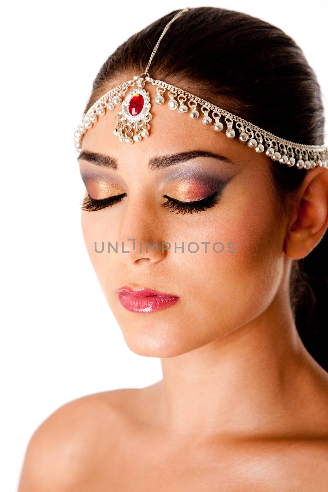 Beautiful face of a Middle Eastern woman with Arabic style makeup and head jewelry, typacally used by Indian belly dancers, isolated.