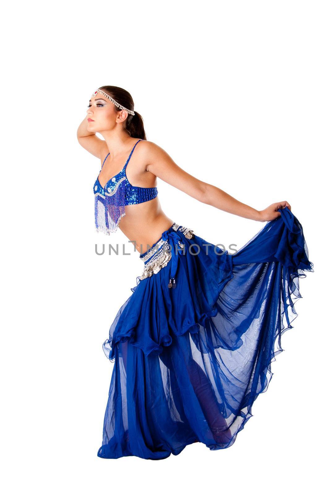 Beautiful Arabic belly dancer harem woman in blue with silver dress and head jewelry with gem dancing holding skirt, isolated.