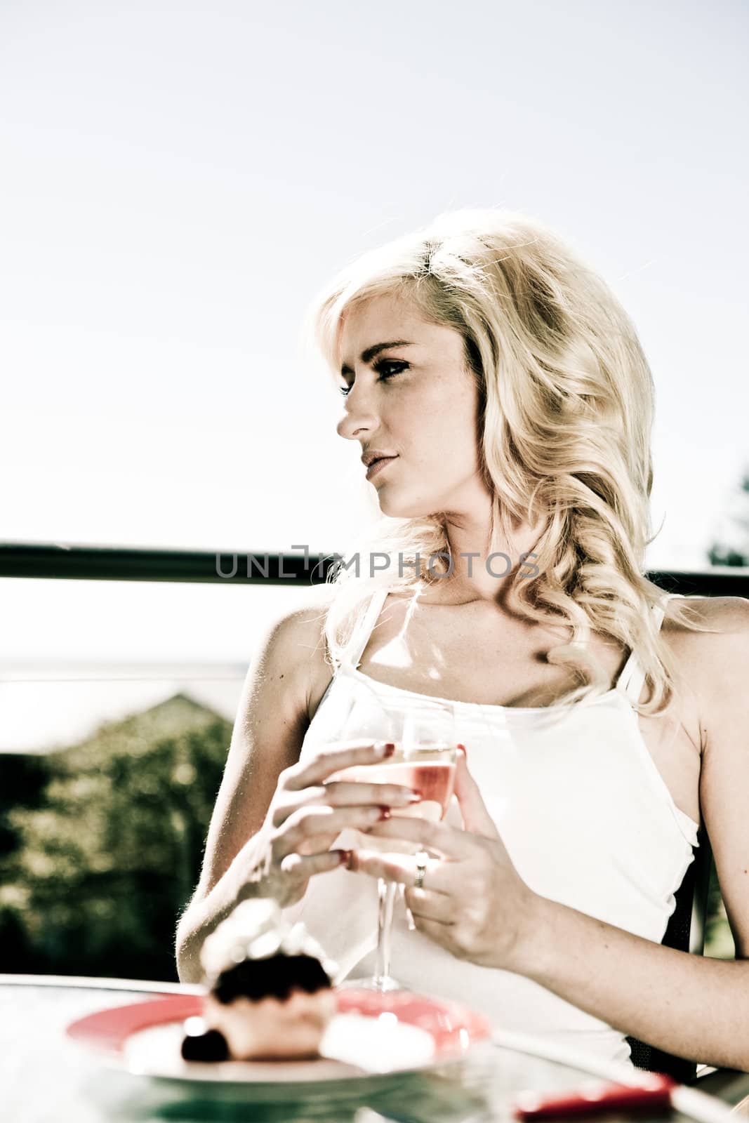 beautiful woman sits at restaurant table with wine by herself