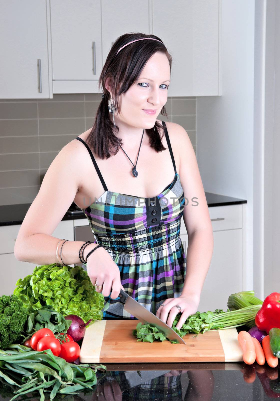 pretty young woman chopping and preparing vegetables