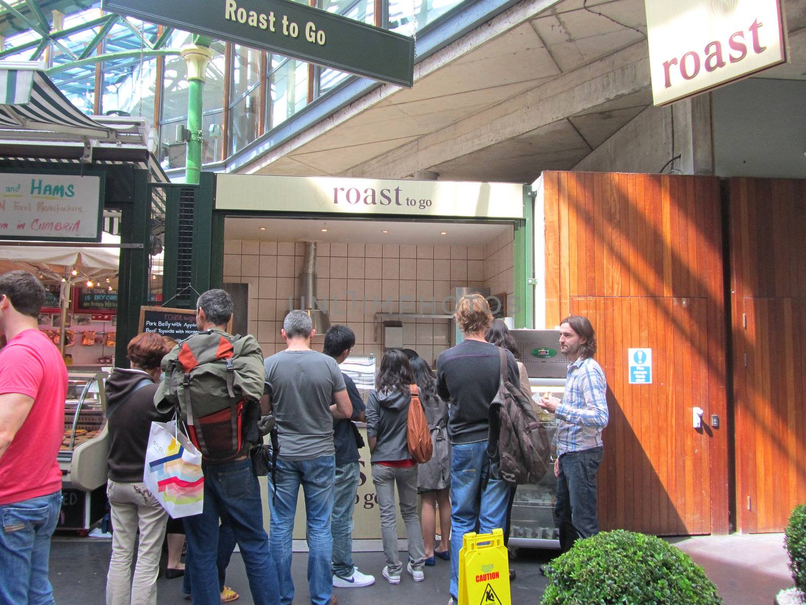 LONDON - AUGUST 14: Queue of people at Roast meats stall at Borough Market on August 14, 2010 in London. Borough Market is one of the largest gourmet food markets in London.                          