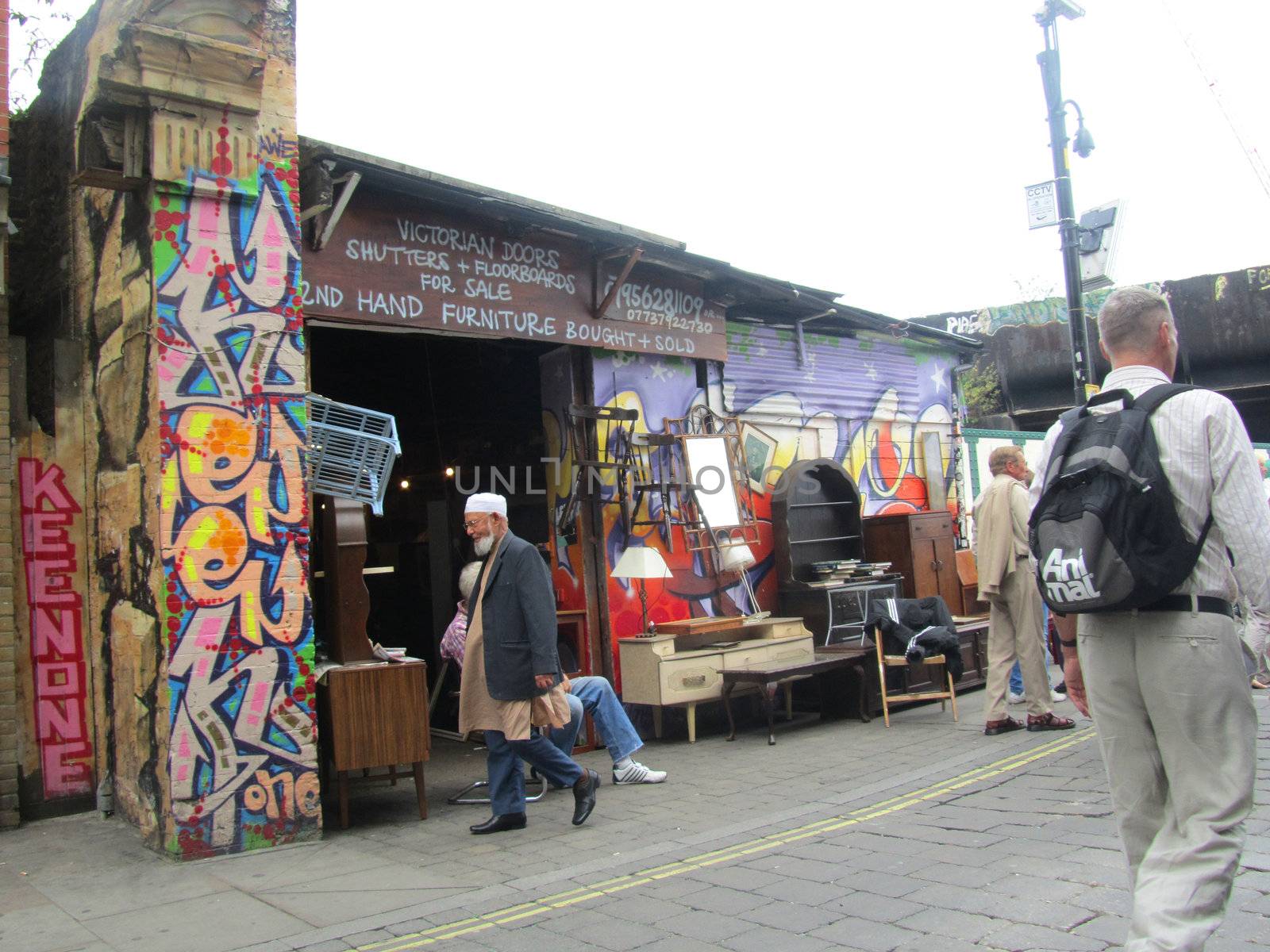 Unidentified visitors near a furniture shop at Brick Lane Market by green308