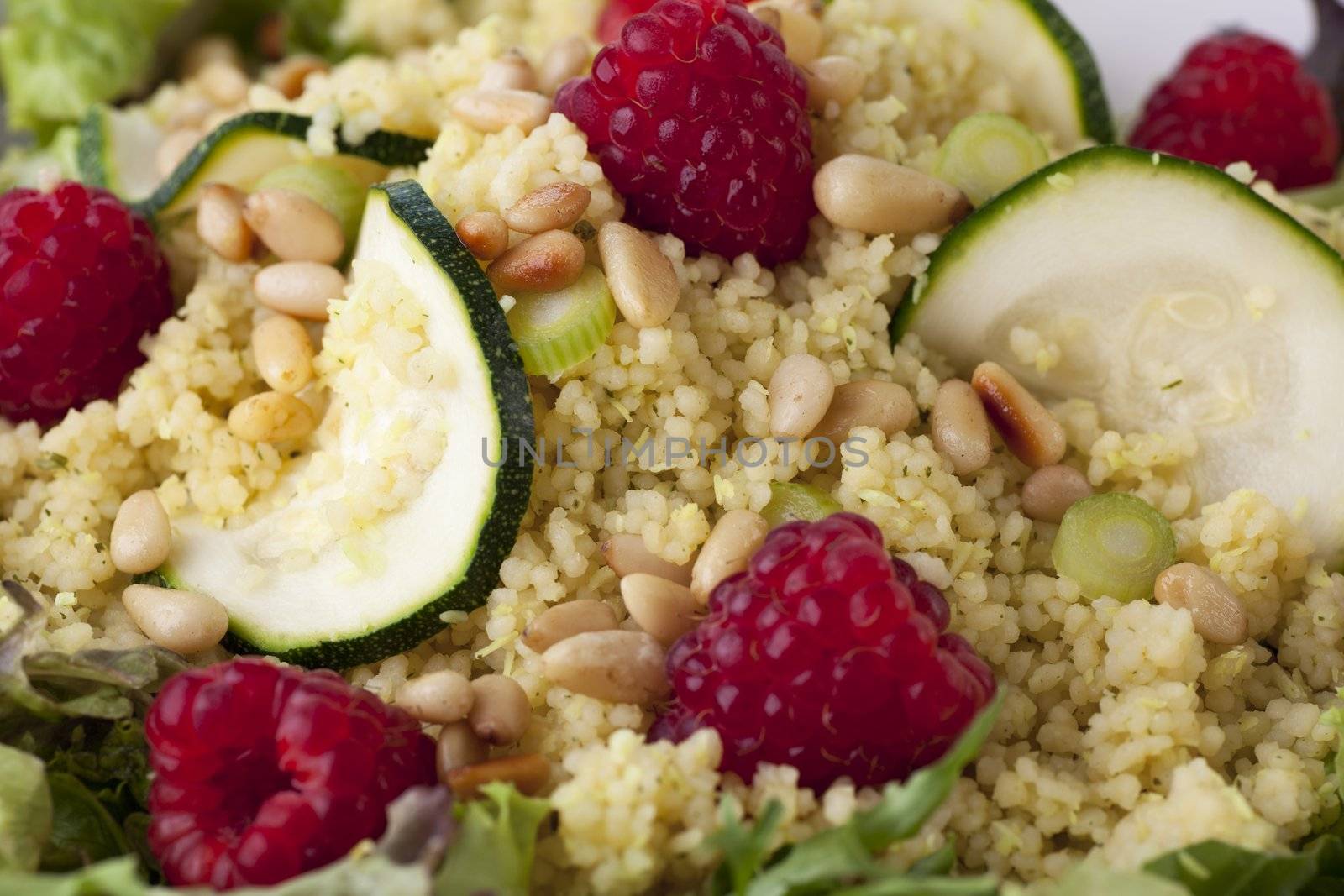 Couscous salad with zucchini and raspberries and pine nuts.