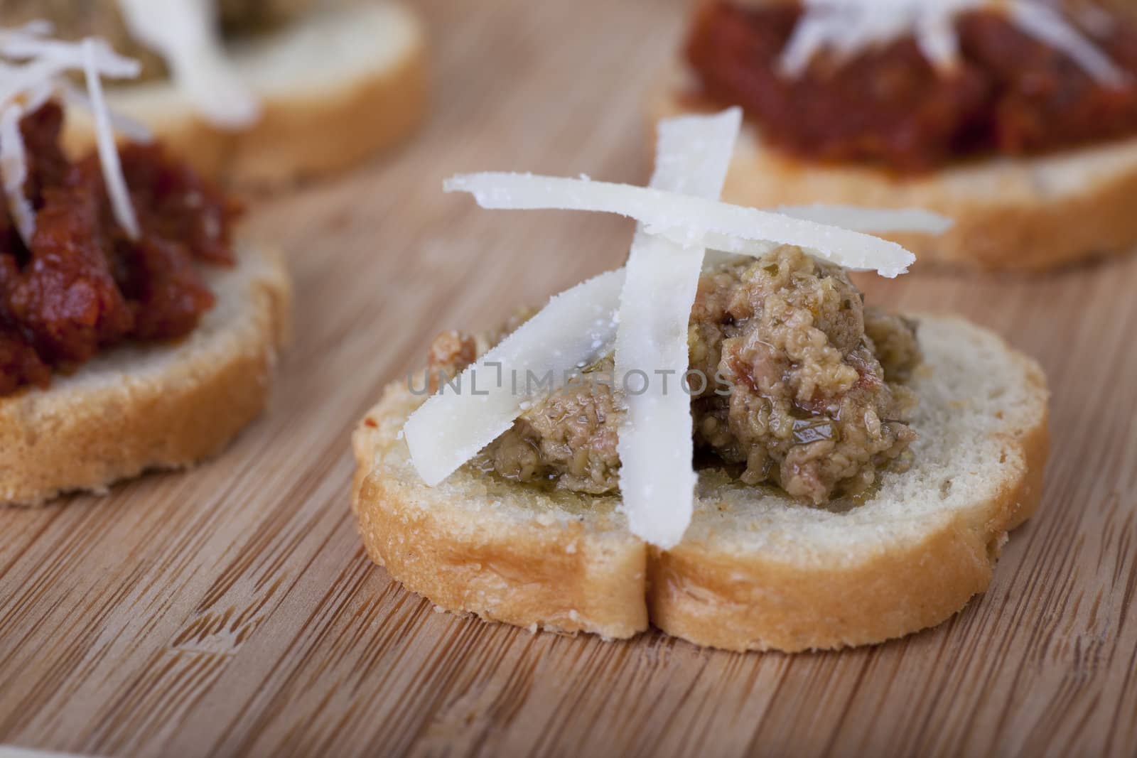 Green olive tapenade on lightly toasted baguette slices topped with fresh shredded Parmesan cheese.