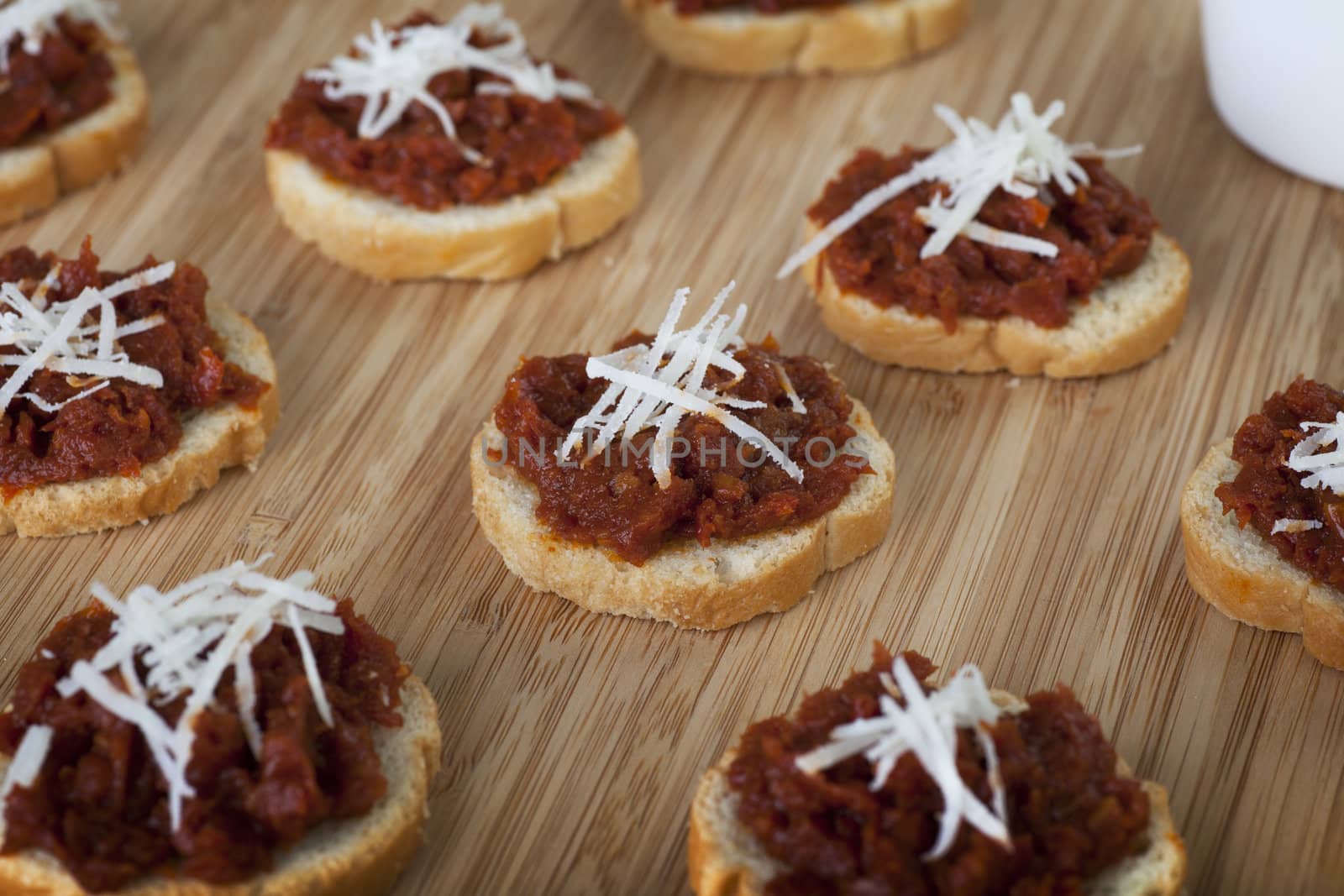 Fresh homemade sun dried tomato tapenade on toasted baguette topped with fresh grated cheese.