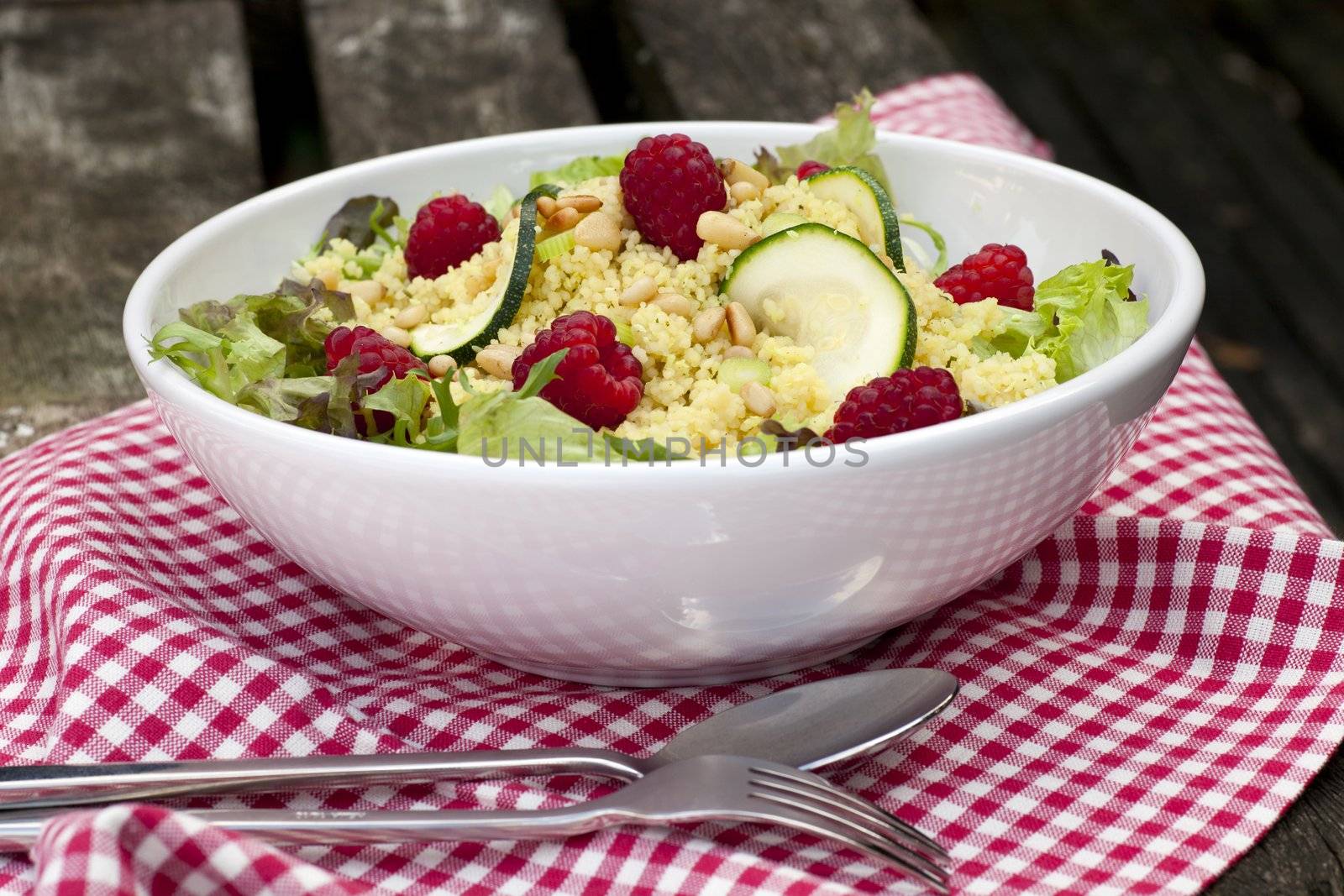 Couscous salad with zucchini and raspberries and pine nuts.