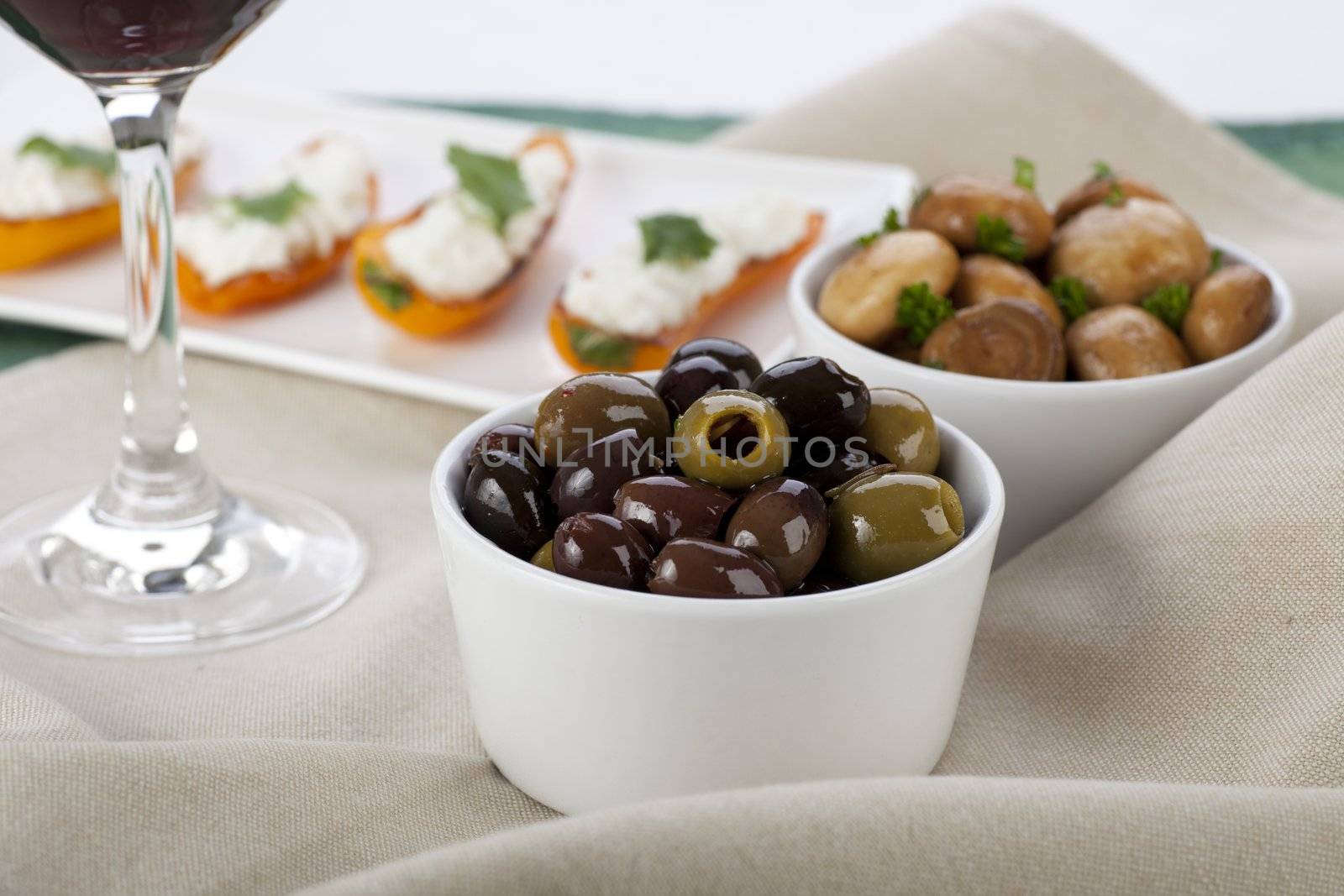 Tapas spread with olives, marinated mushrooms and cheese filled peppers.