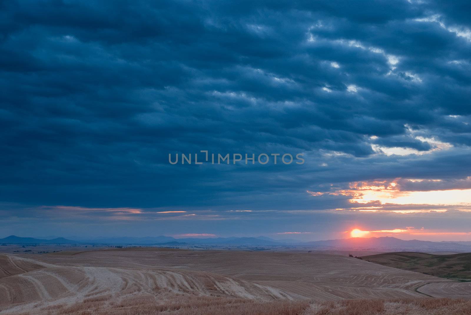 Stormy sunrise, harvested wheat field and The Clearwater Mountains, Latah County, Idaho, USA