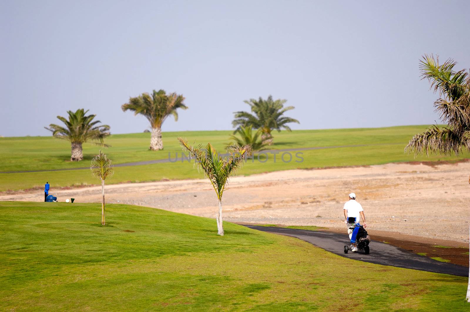 Golfer walking at path to next hole