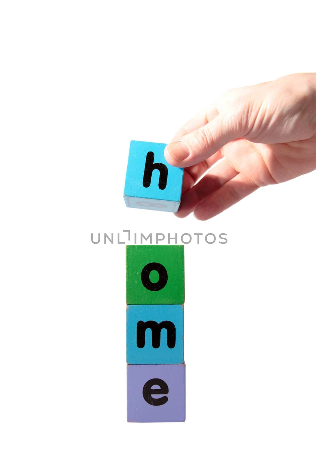 toy letters that spell home against a white background with clipping path with hand