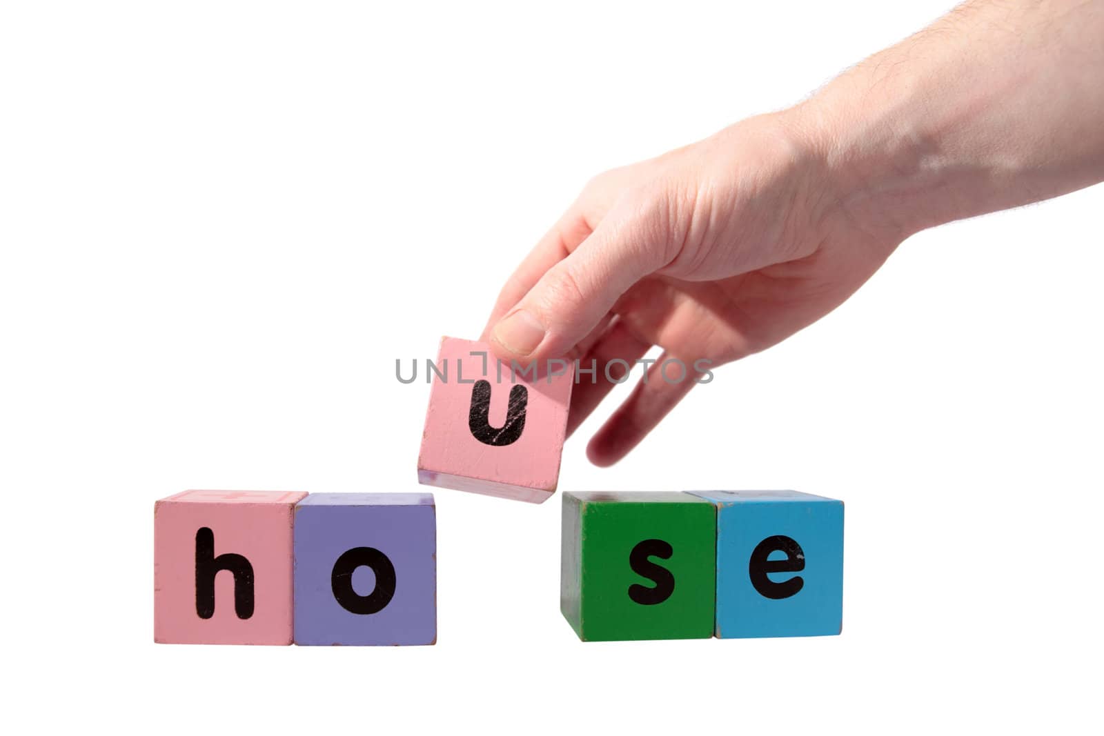 toy letters that spell house against a white background with clipping path with hand