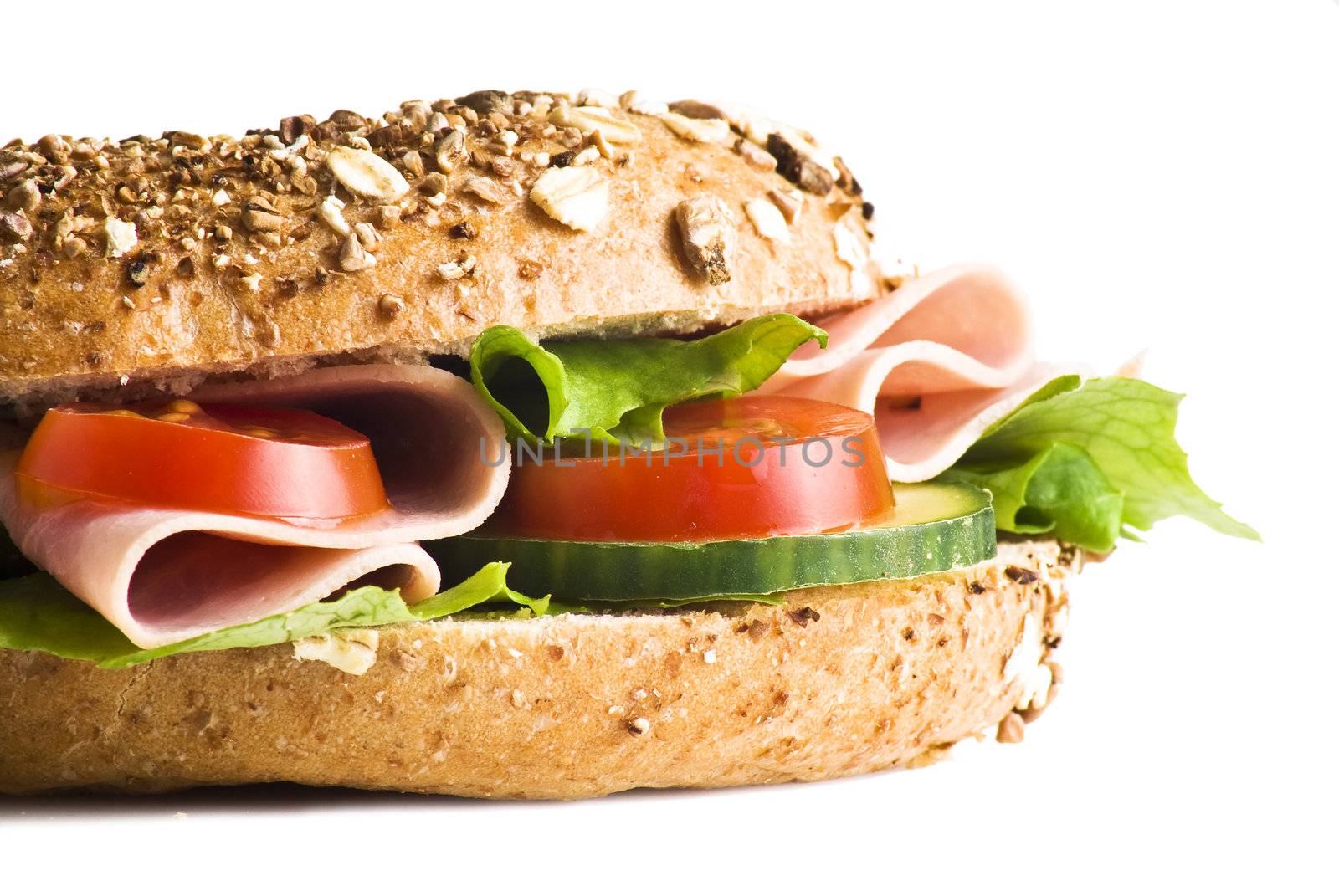 Freshly made sandwich with ham and vegetables over white background