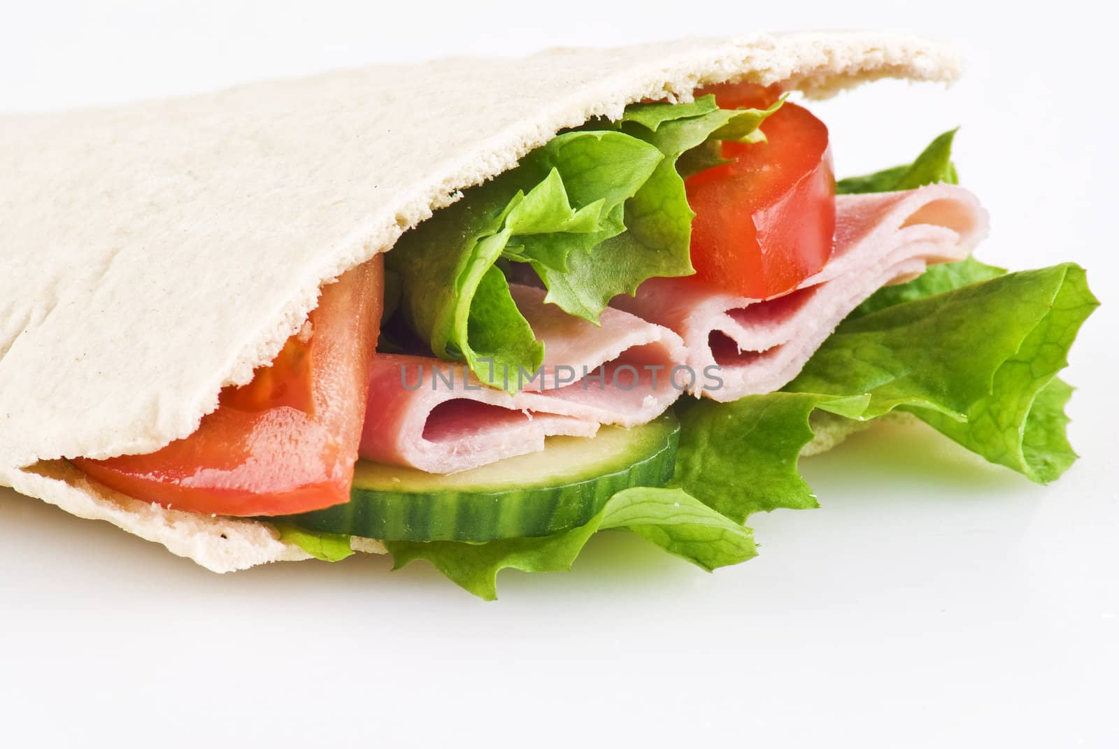 Pitta bread pocket filled with salad tomato cucumber and ham