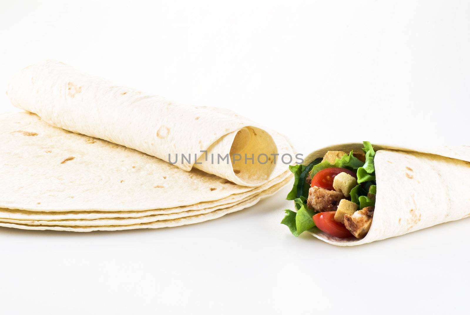 Tortilla filled with lettuce chicken tomatoes and cucumber with plain tortillas