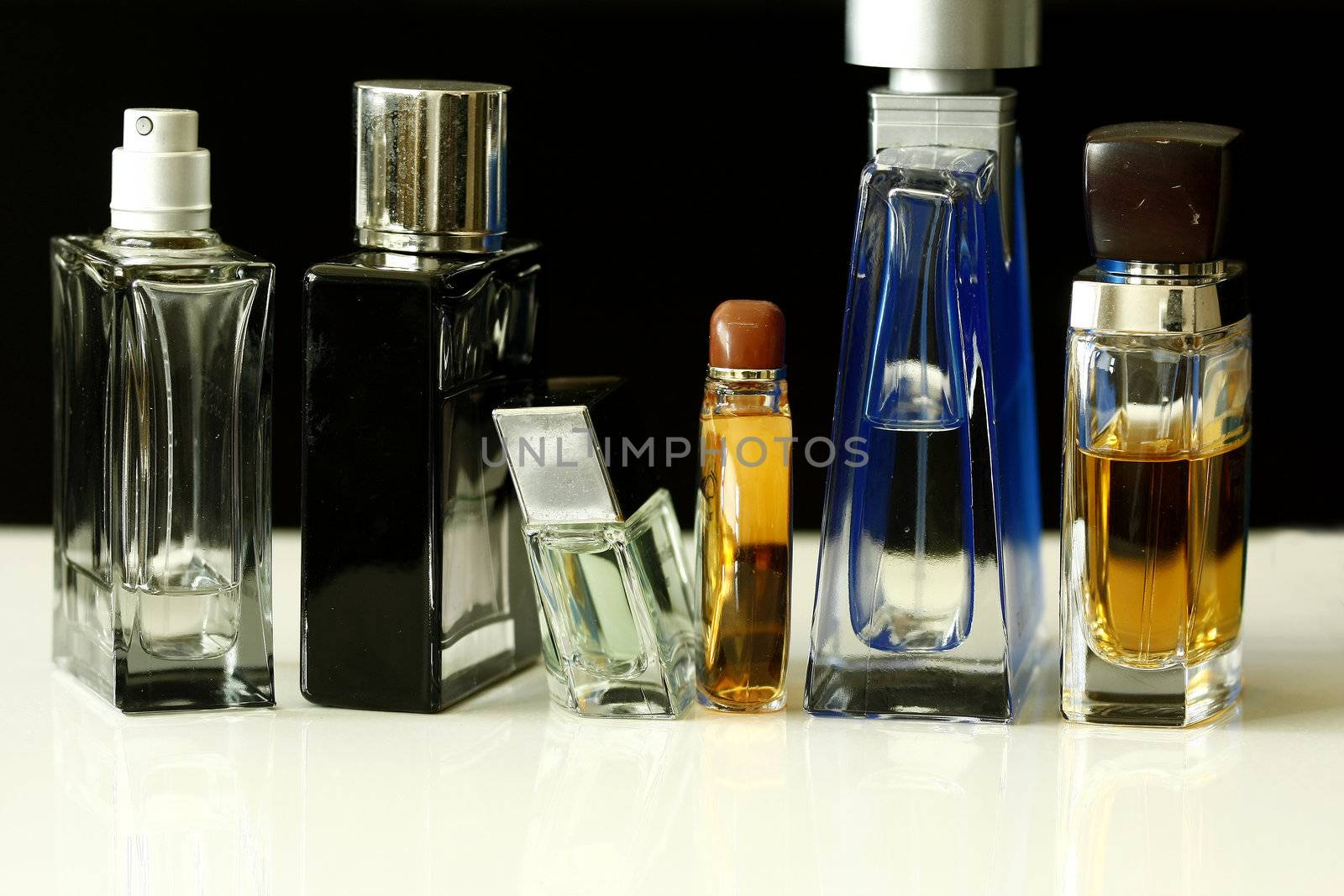 Perfume and Fragrances bottles with reflection in dark barkground.