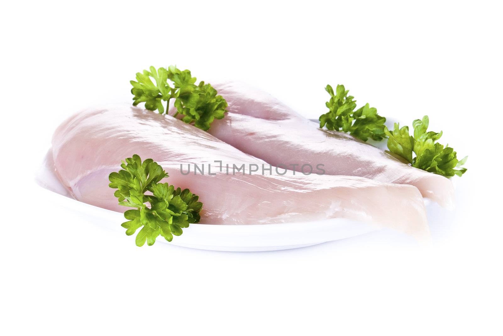 Raw chicken breasts on the plate with parsley - isolated