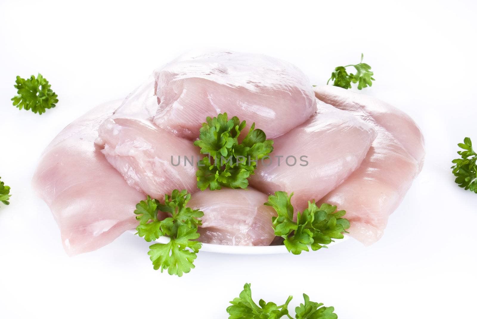 Raw chicken breasts on the plate with parsley - isolated