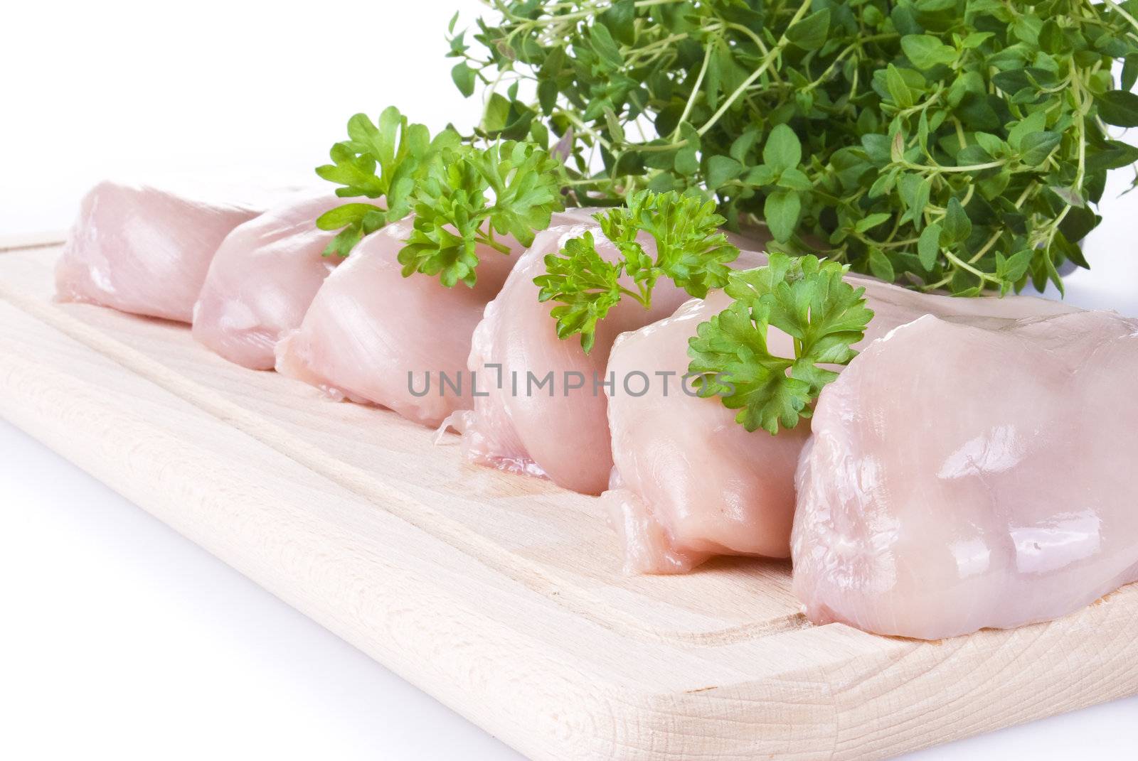 Raw chicken breasts on chopping board by caldix