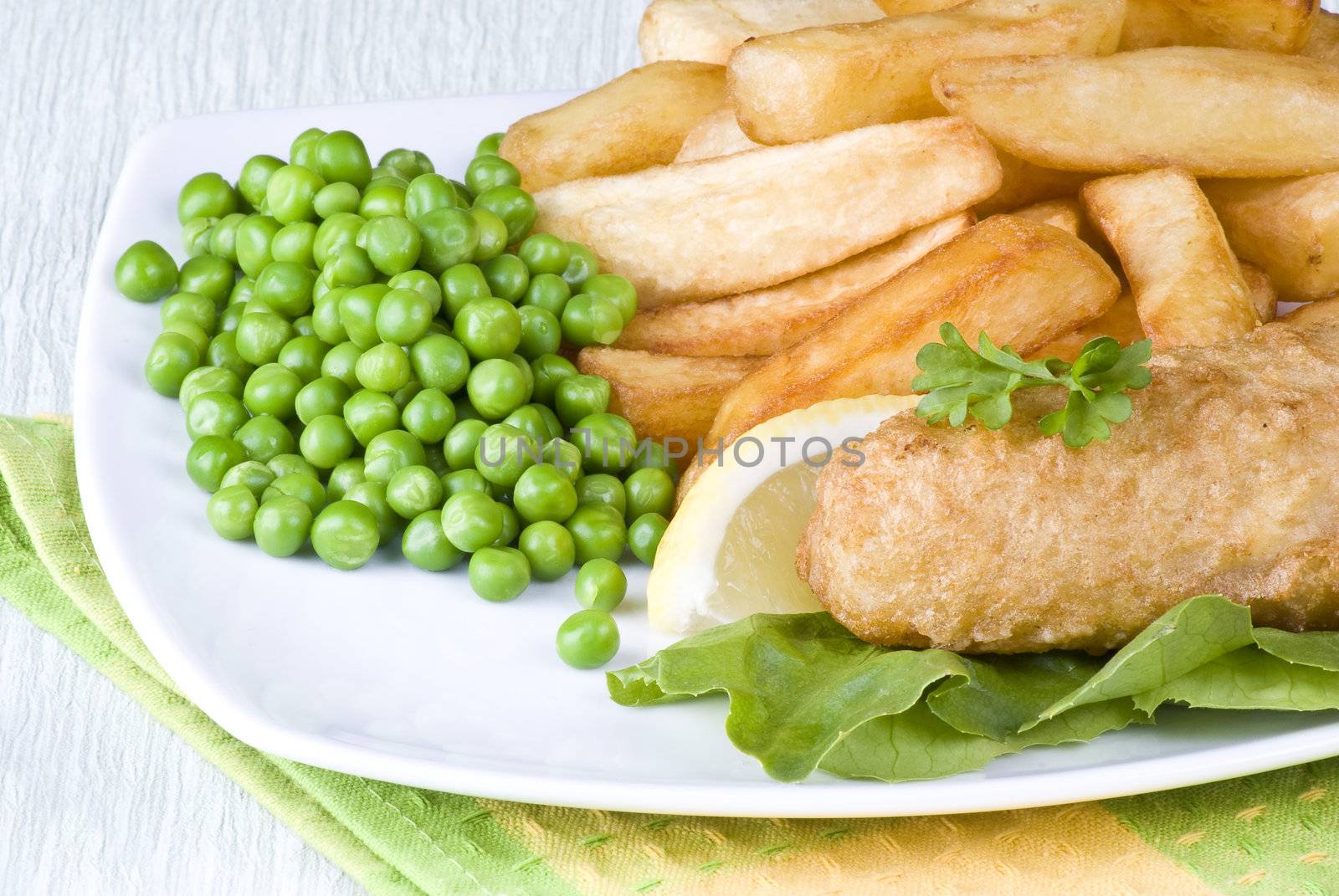 Fried fish and chips with lemon and peas