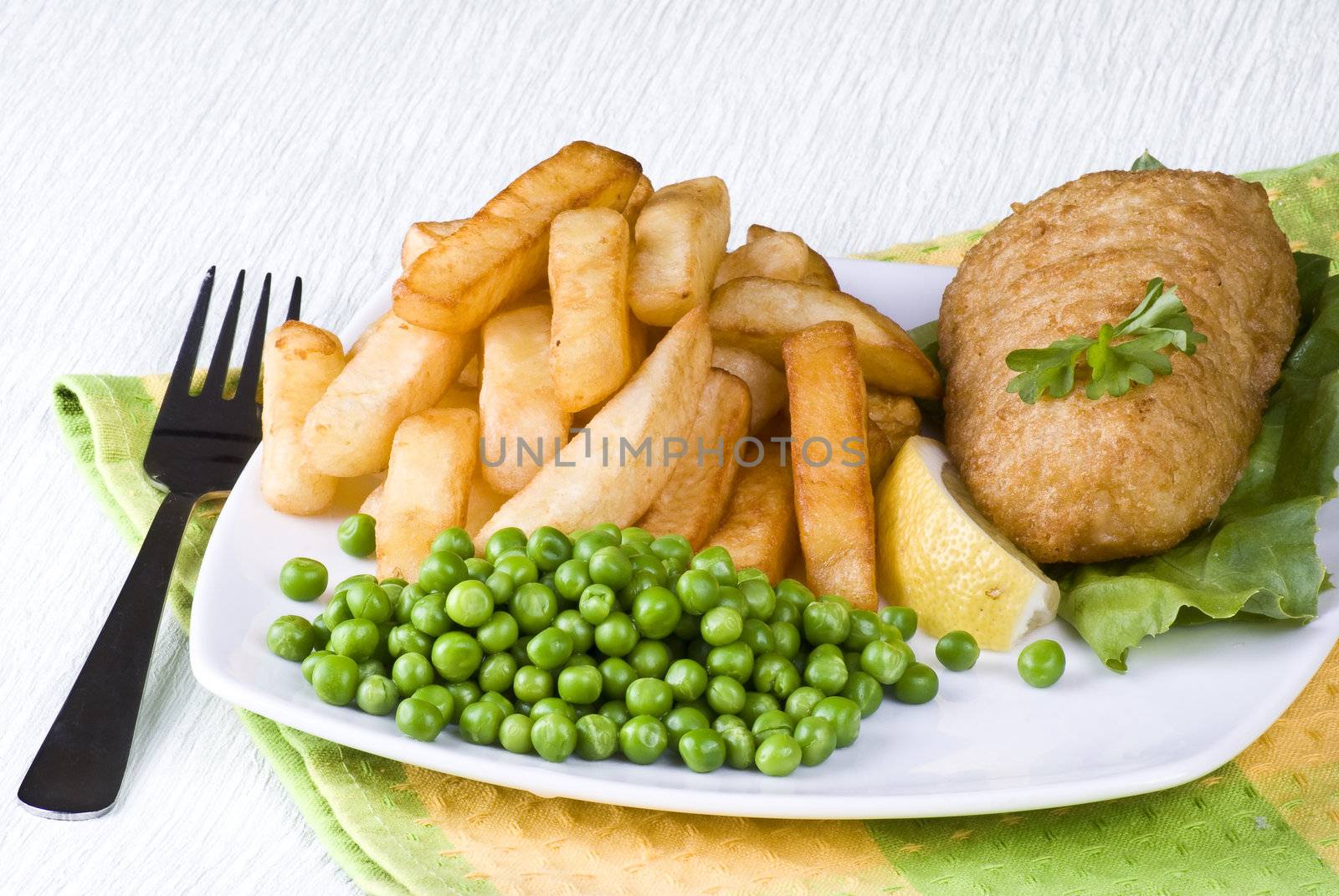 Fried fish and chips with lemon and peas