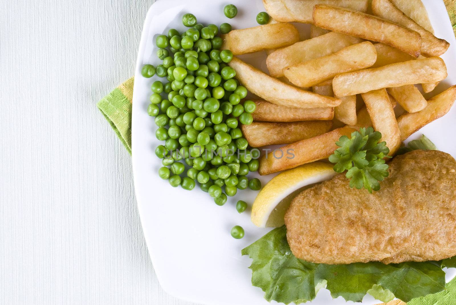 Fried fish and chips with lemon and peas