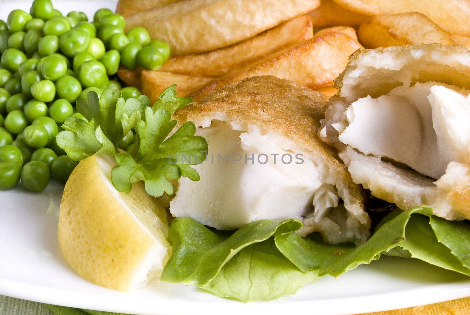 Fried fish and chips with lemon and peas
