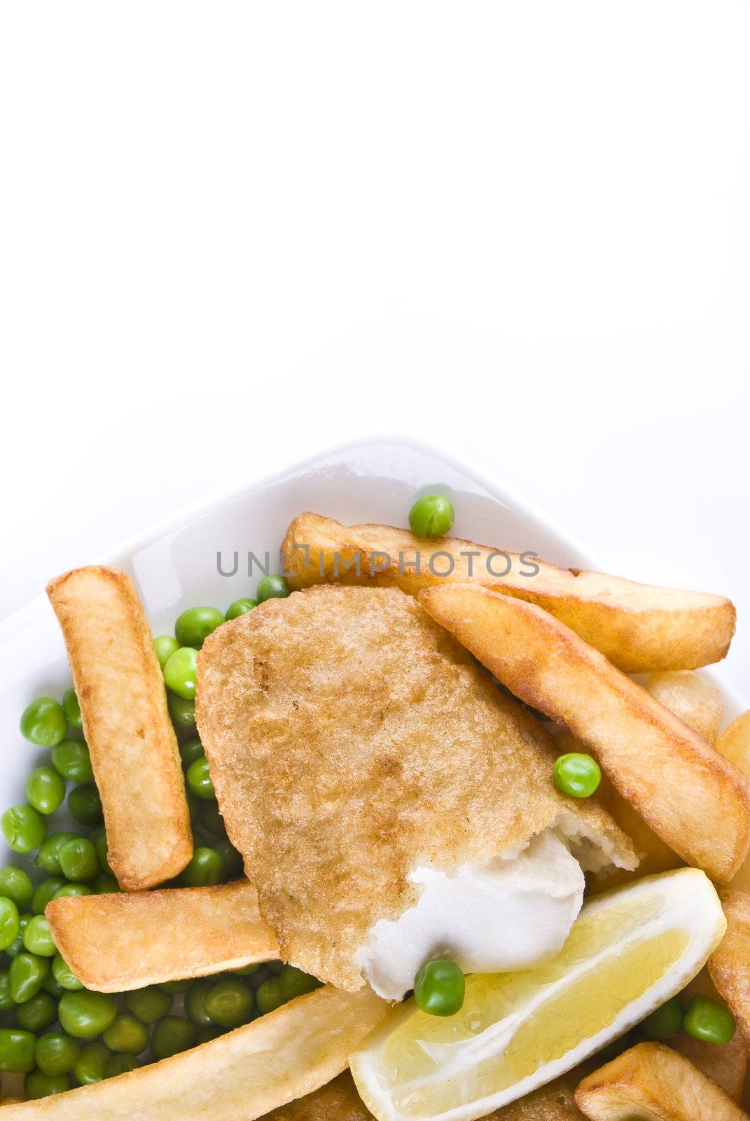 Fried fish and chips with lemon and peas - isolated