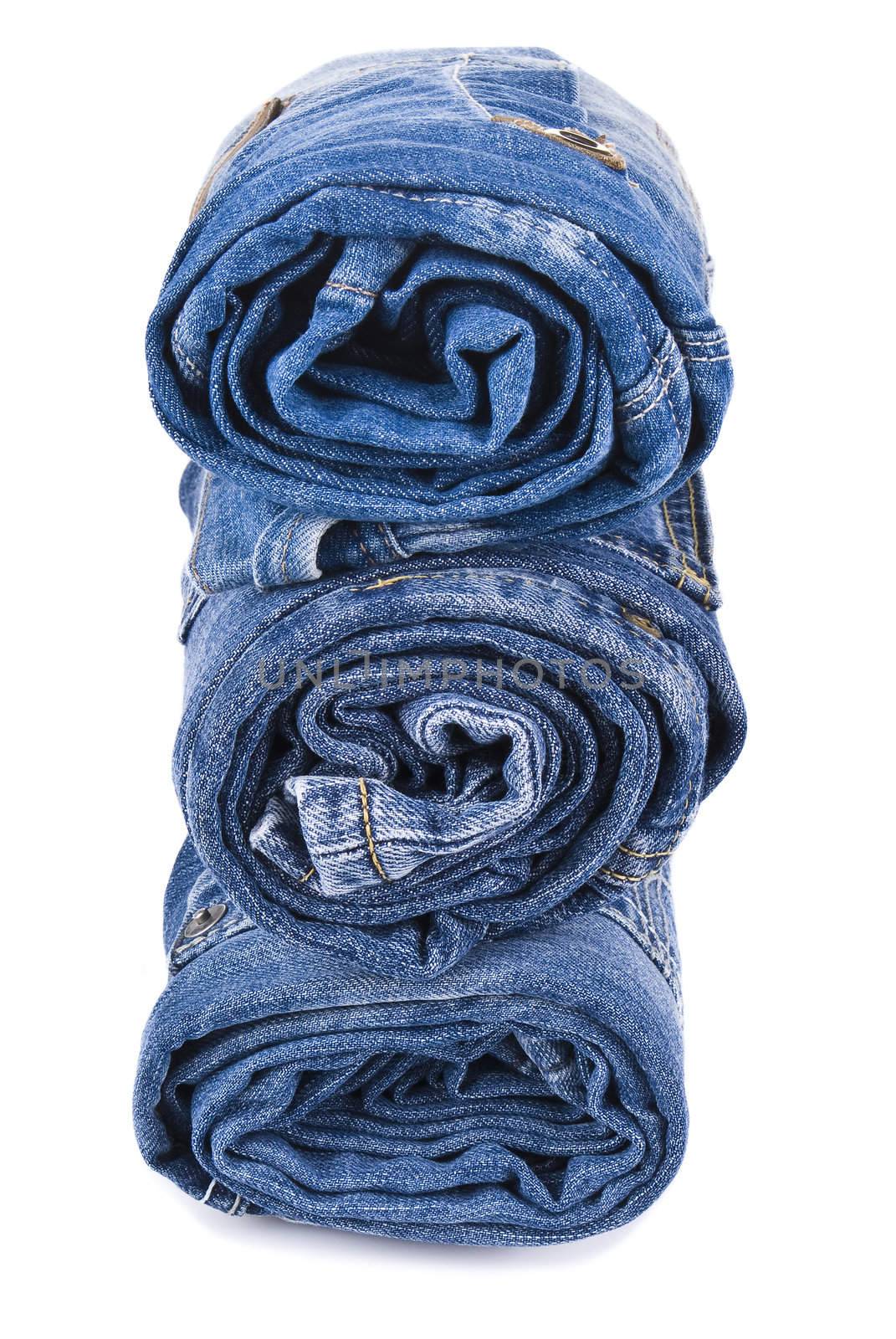 stack of various shades of blue jeans over white background