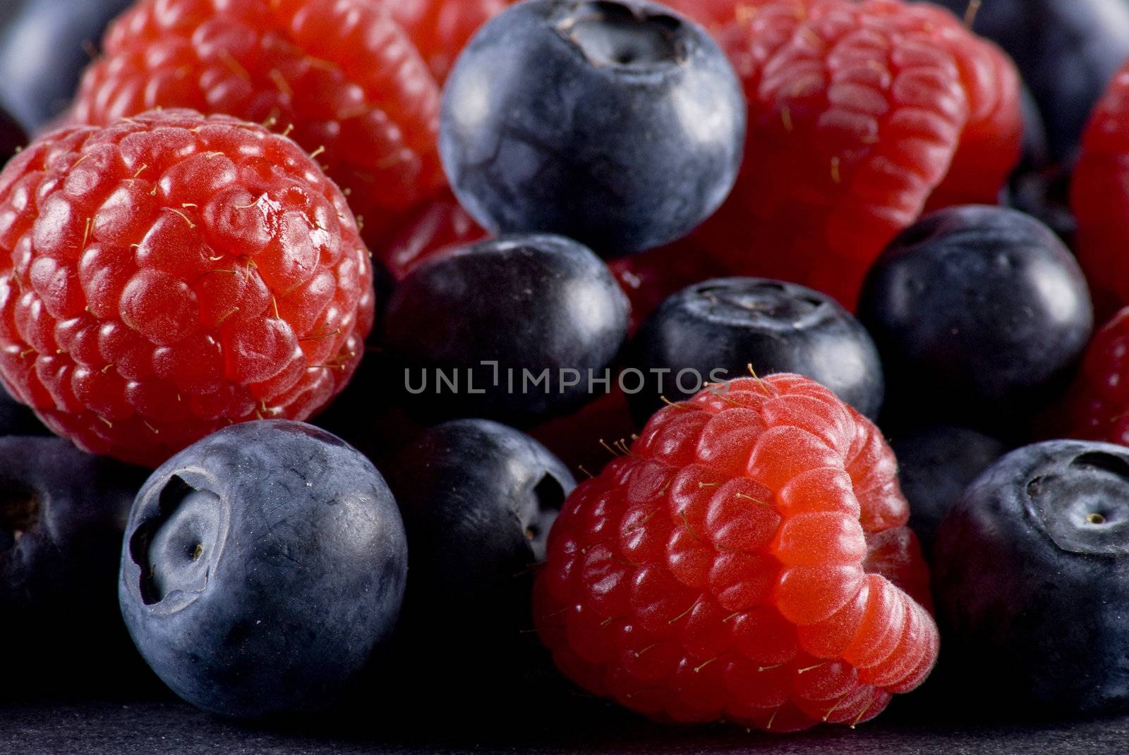 Closeup of fresh blueberries and raspberries mixed toghether