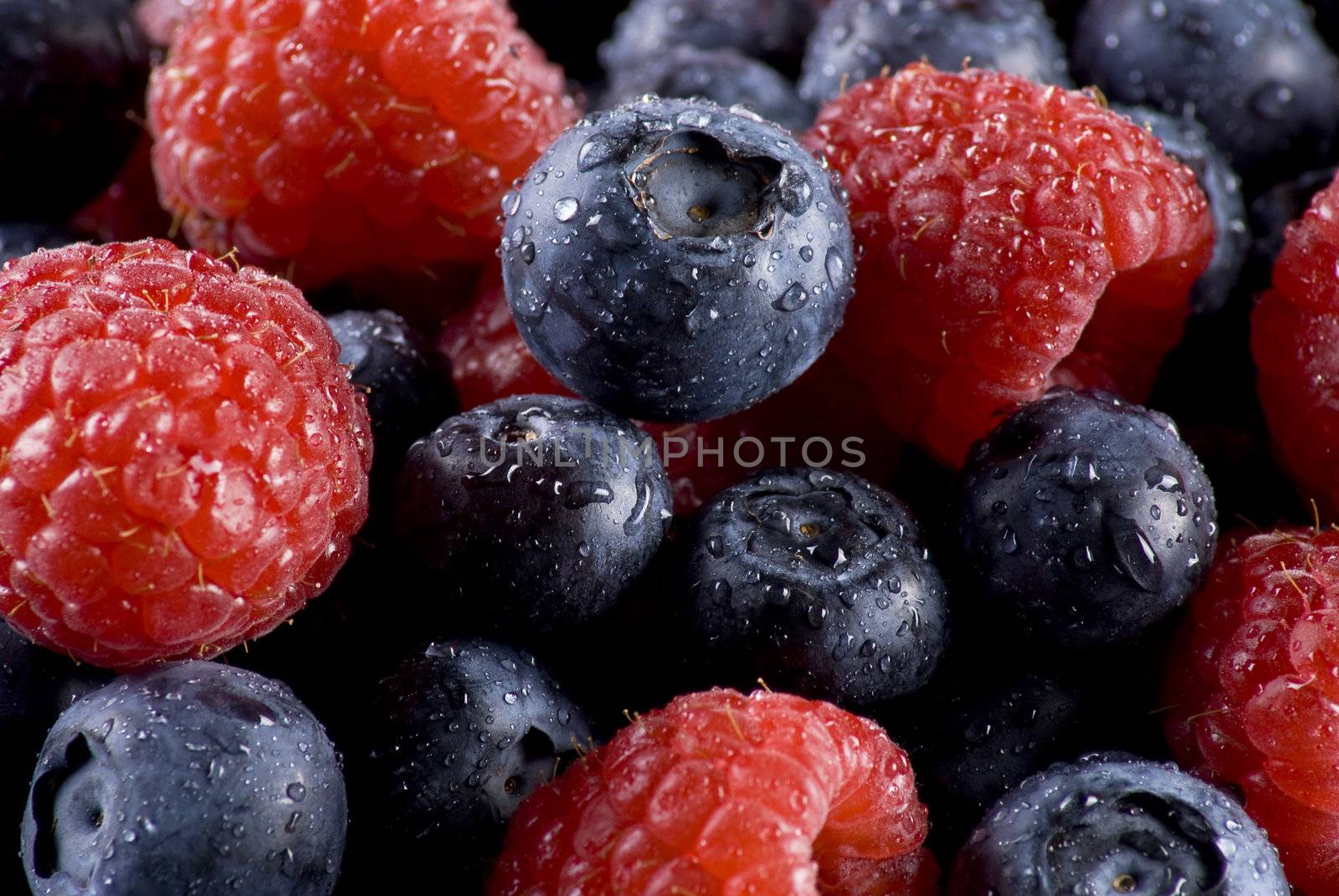 Closeup of fresh blueberries and raspberries mixed toghether