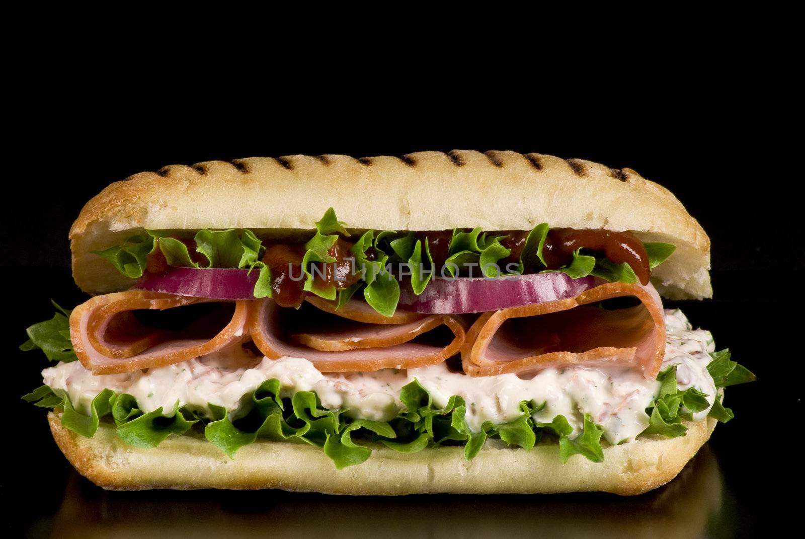 Ham and vegetable sandwich on a black background