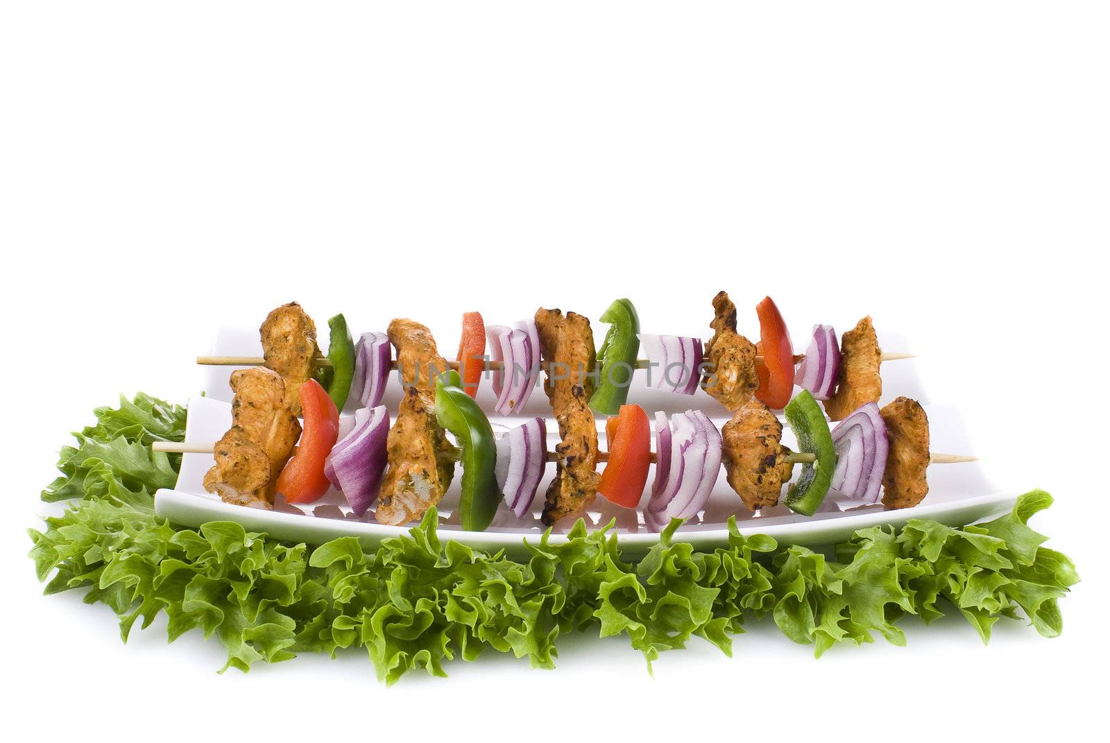 Skewers with chicken and vegetables on the plate - isolated