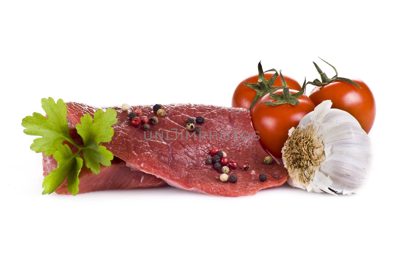 Raw beef frying steak with vegetables isolated over white background