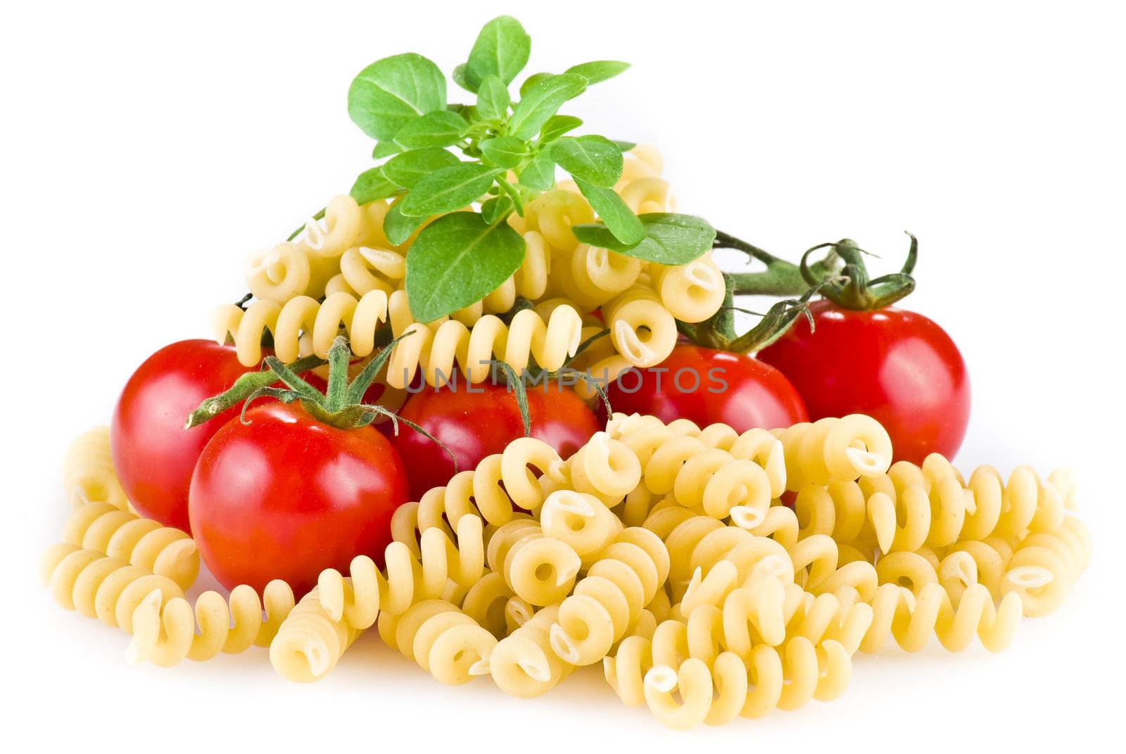 Fusilli pasta with tomatoes and basil over white background