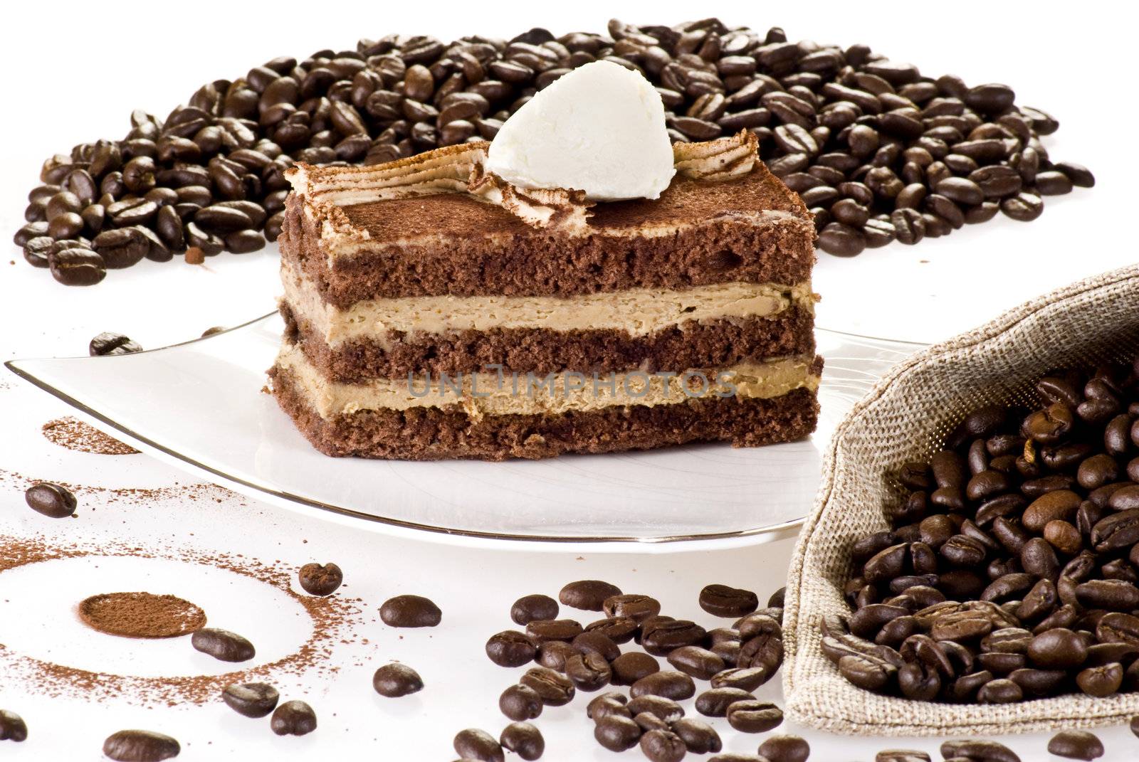 Tiramisu cake on the plate with coffe beans around