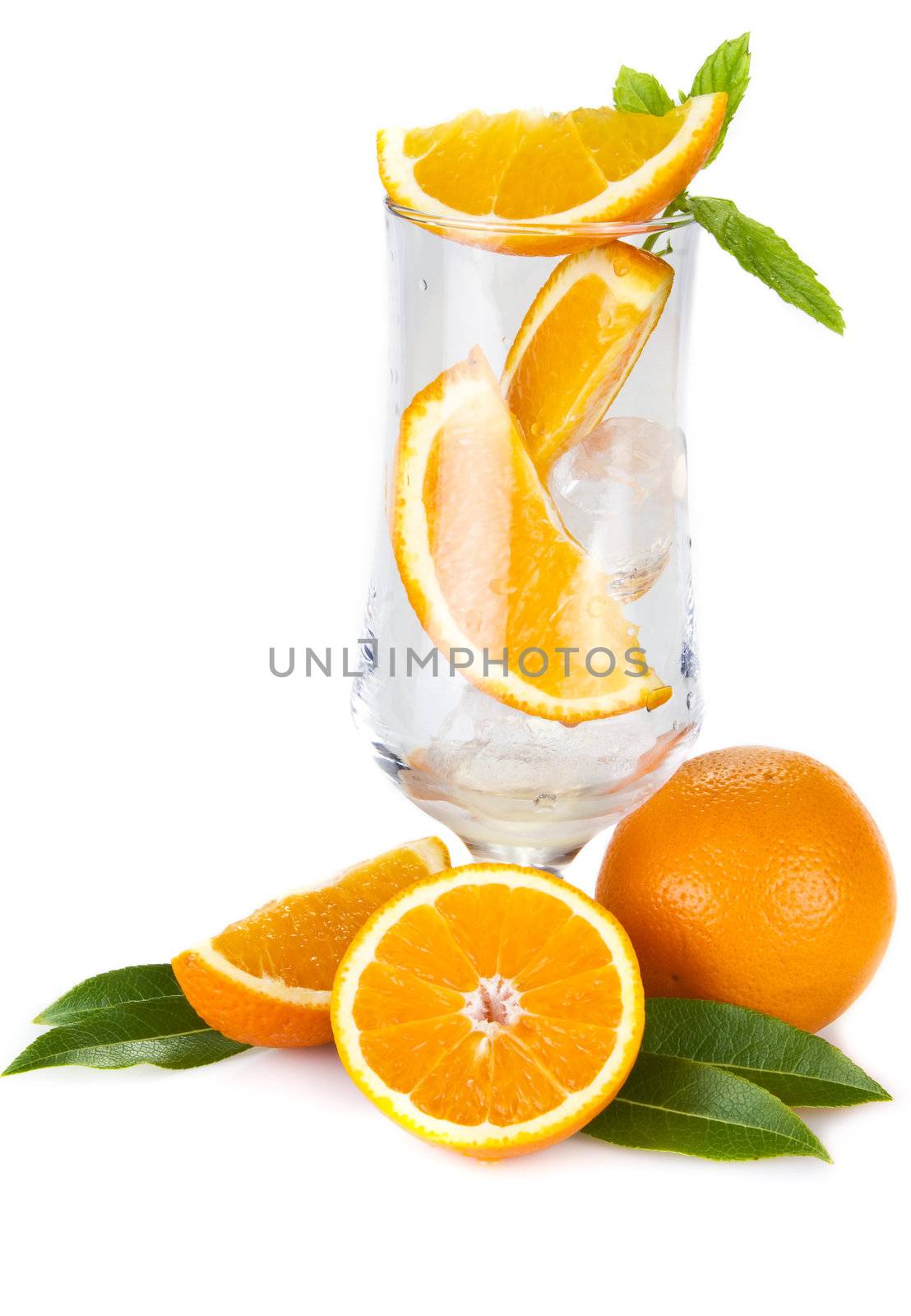 Pieces of orange and mint in the glass isolated over white