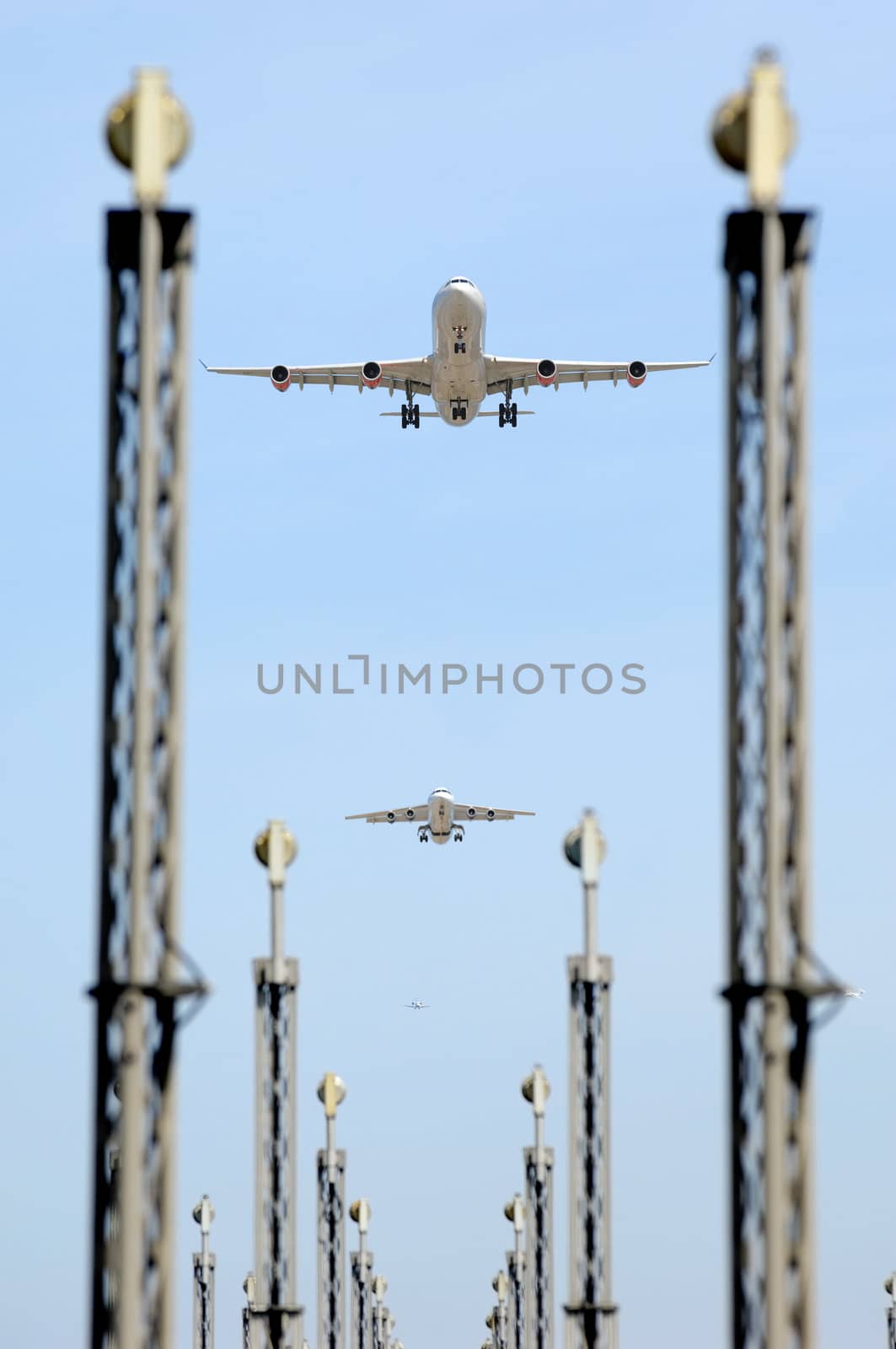 Planes are flying over landing lights in an airport