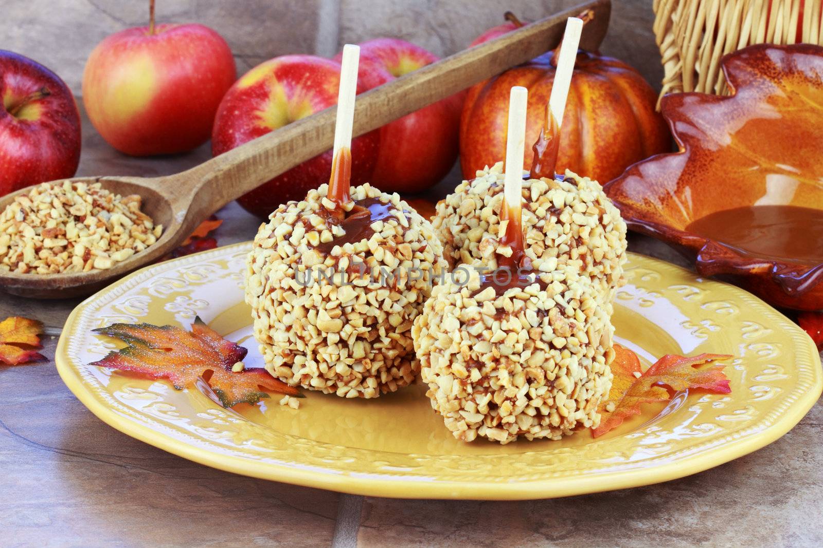Candy apples with caramel sauce and a fresh ingredients in the background.