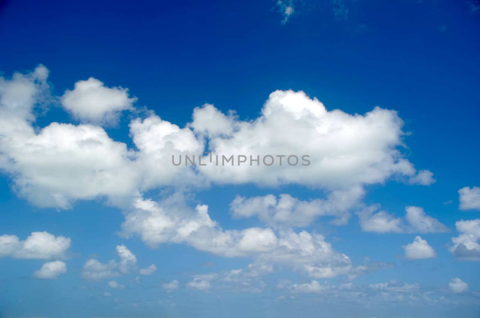 Cloudscape with white cumulus clouds and a blue sky.