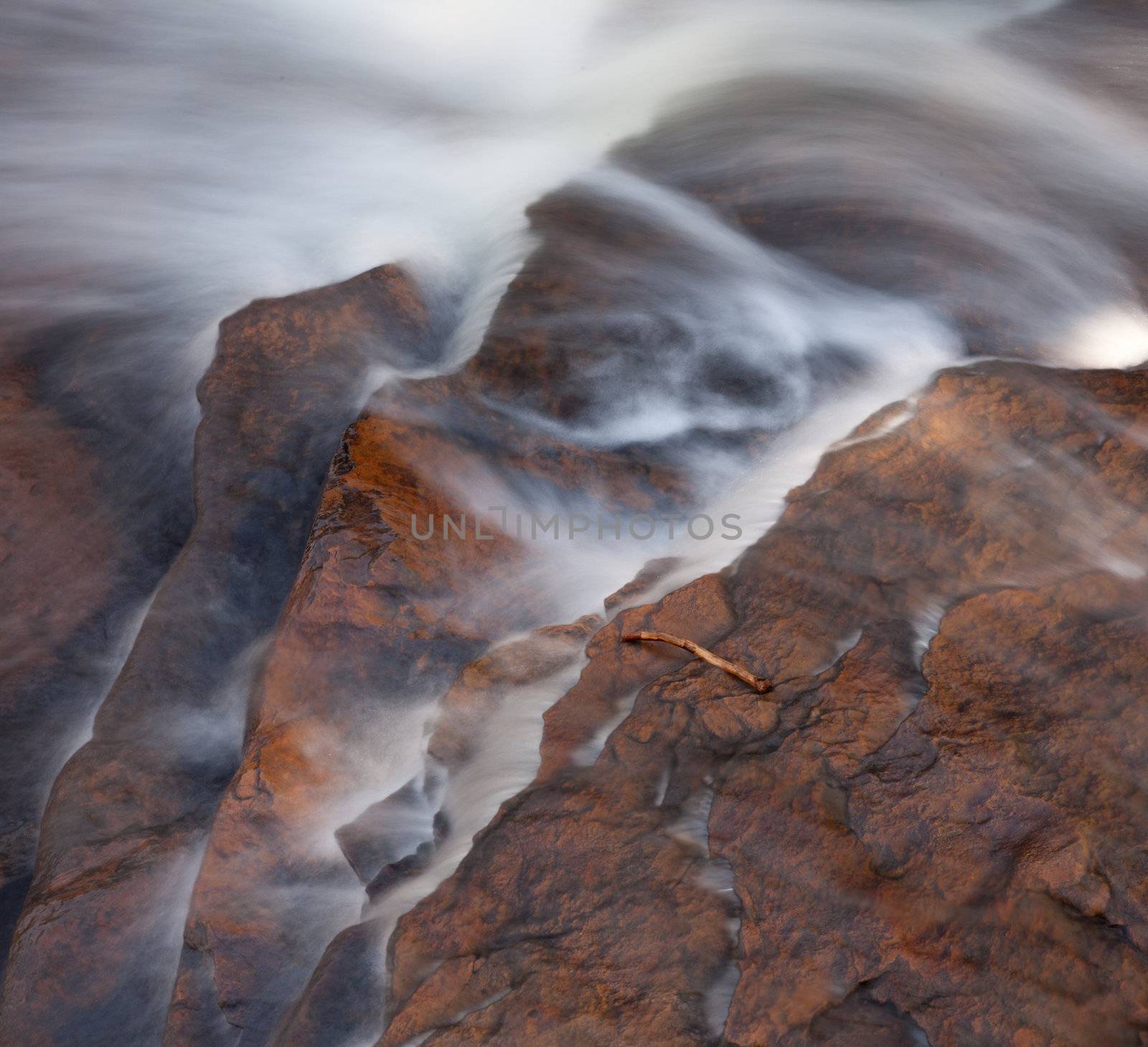 Fallen branch in fall in river by edge of waterfall