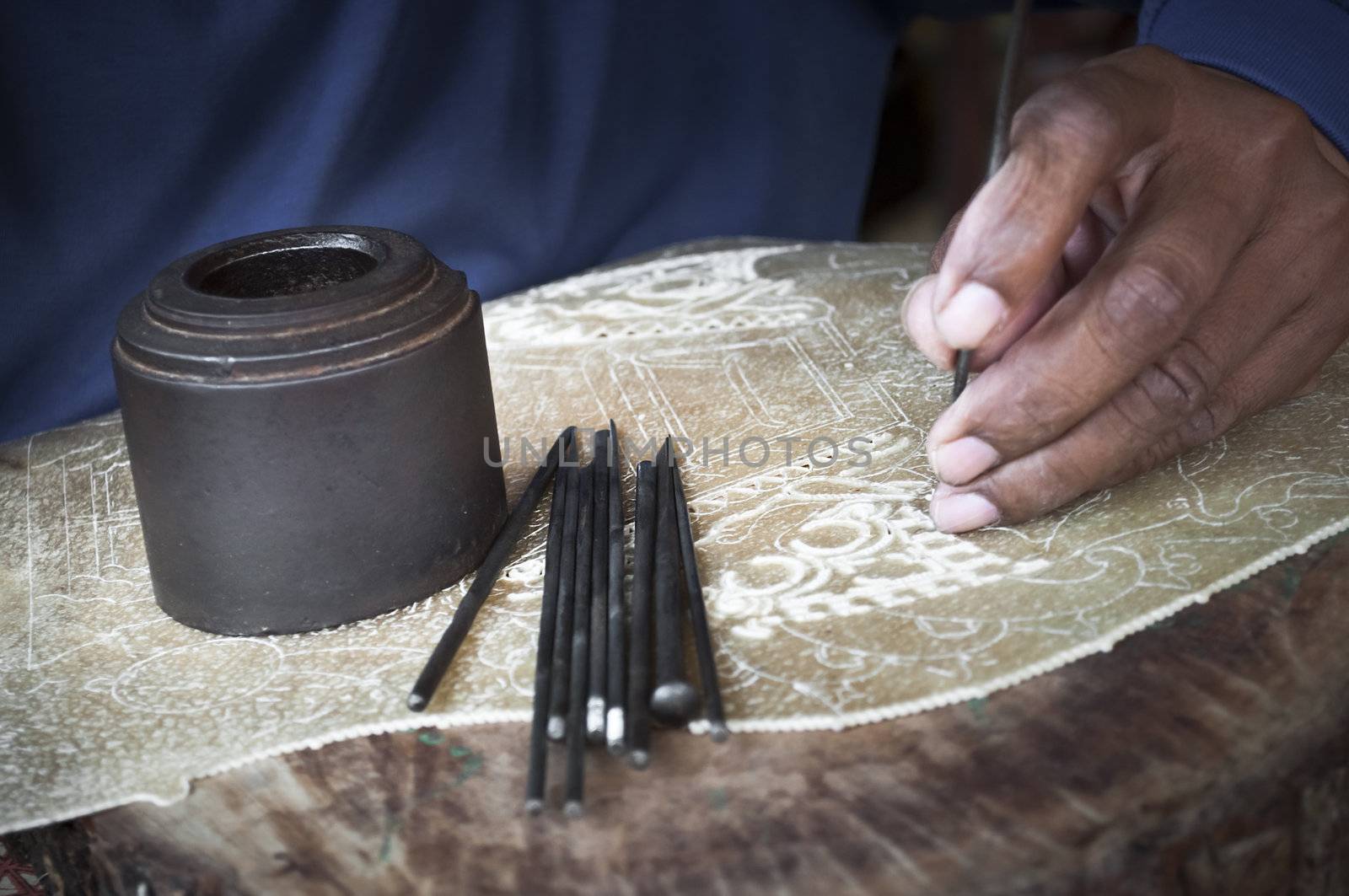 Traditional craftsman carving wood making indonesian puppets