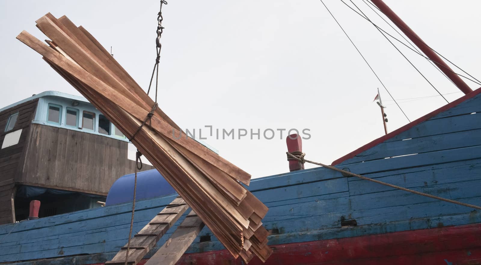 Wooden boards are loading in a cargo ship,Jakarta Indonesia