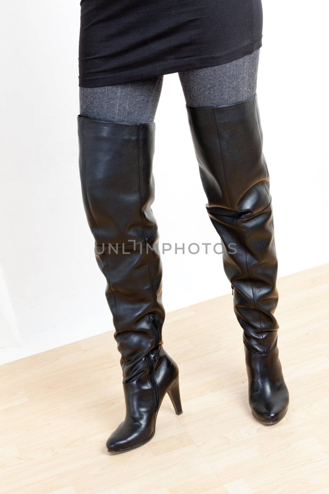 detail of standing woman wearing fashionable black boots