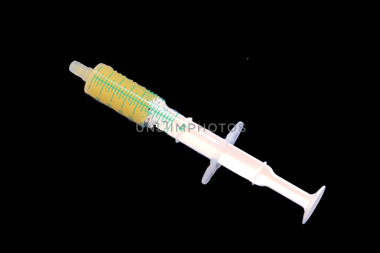 Plastic syringe with orange juice