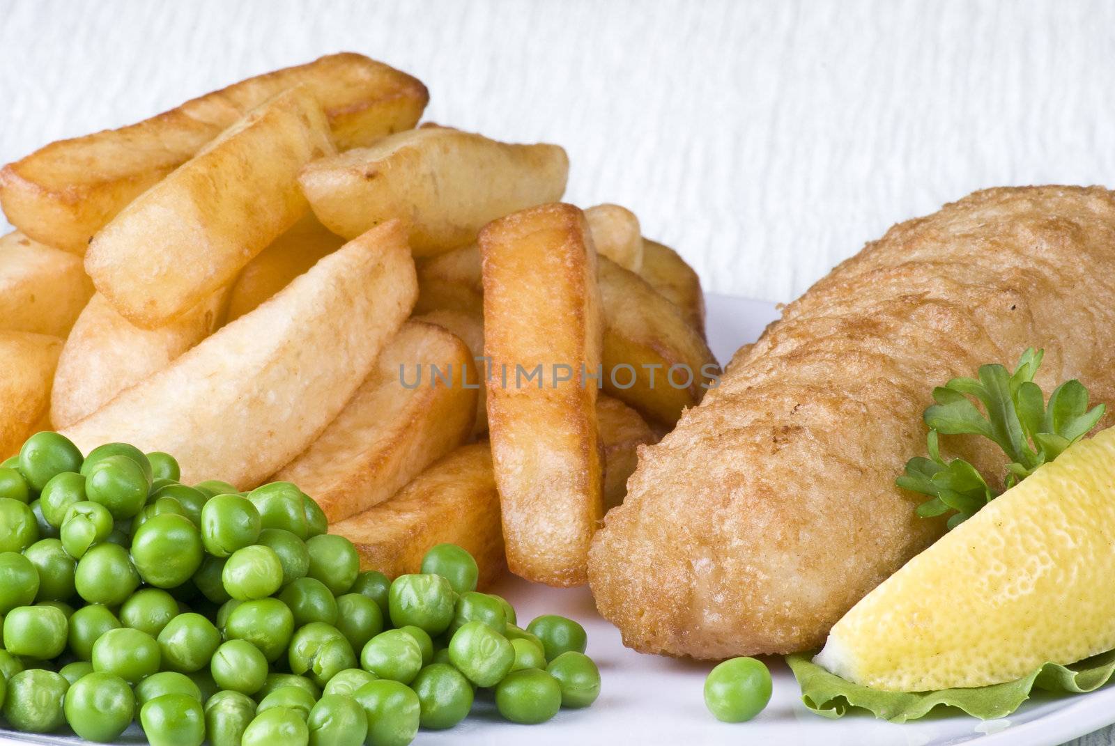 Fried fish and chips with lemon and peas