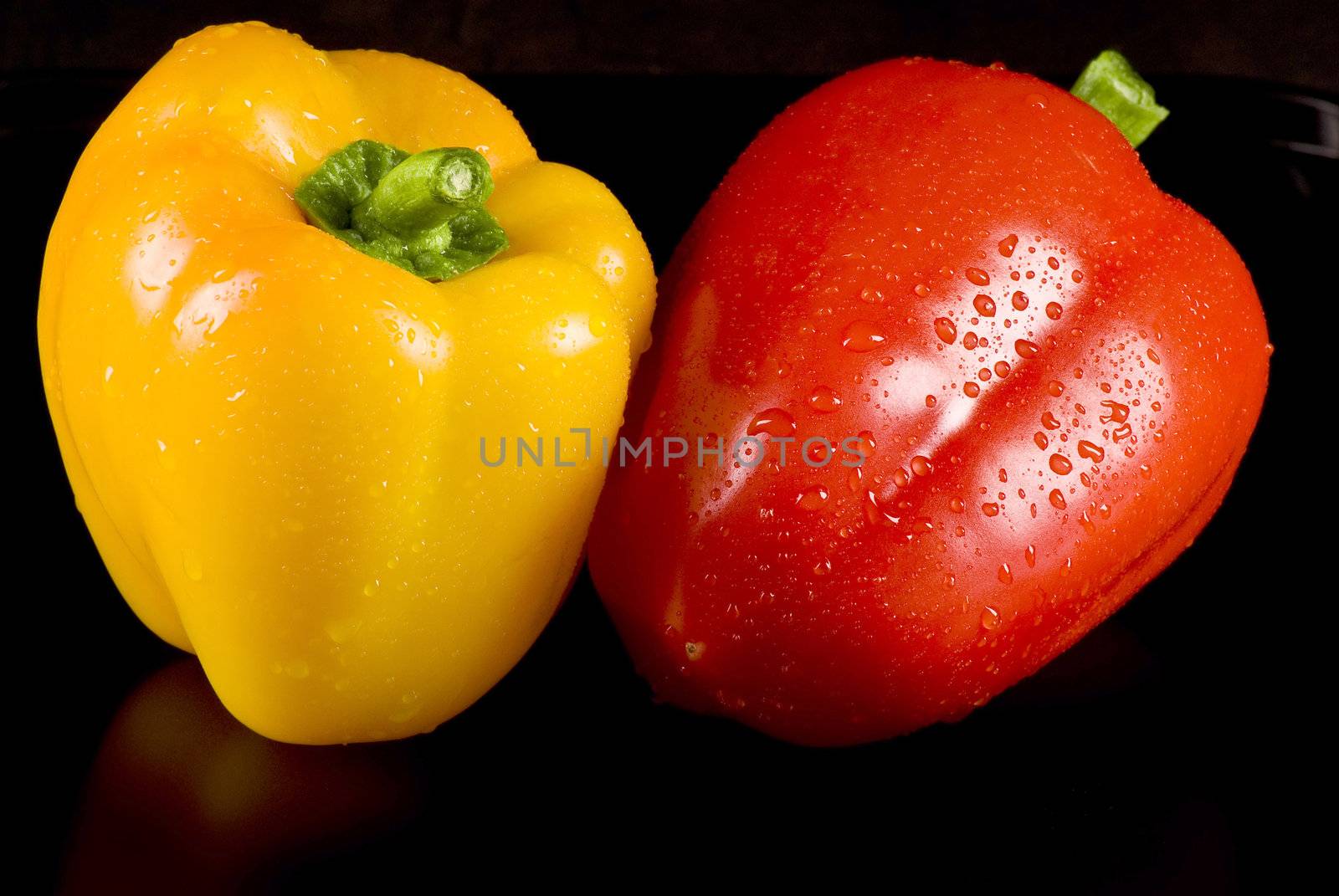 Yellow and red peppers on a black background