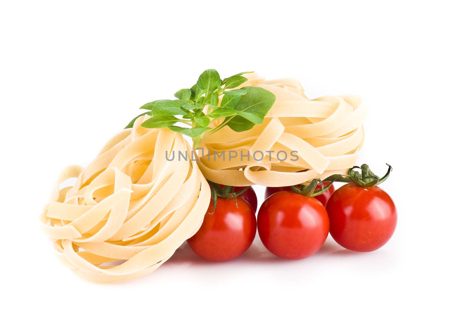 Tagiatelle pasta with tomatoes and basil over white background