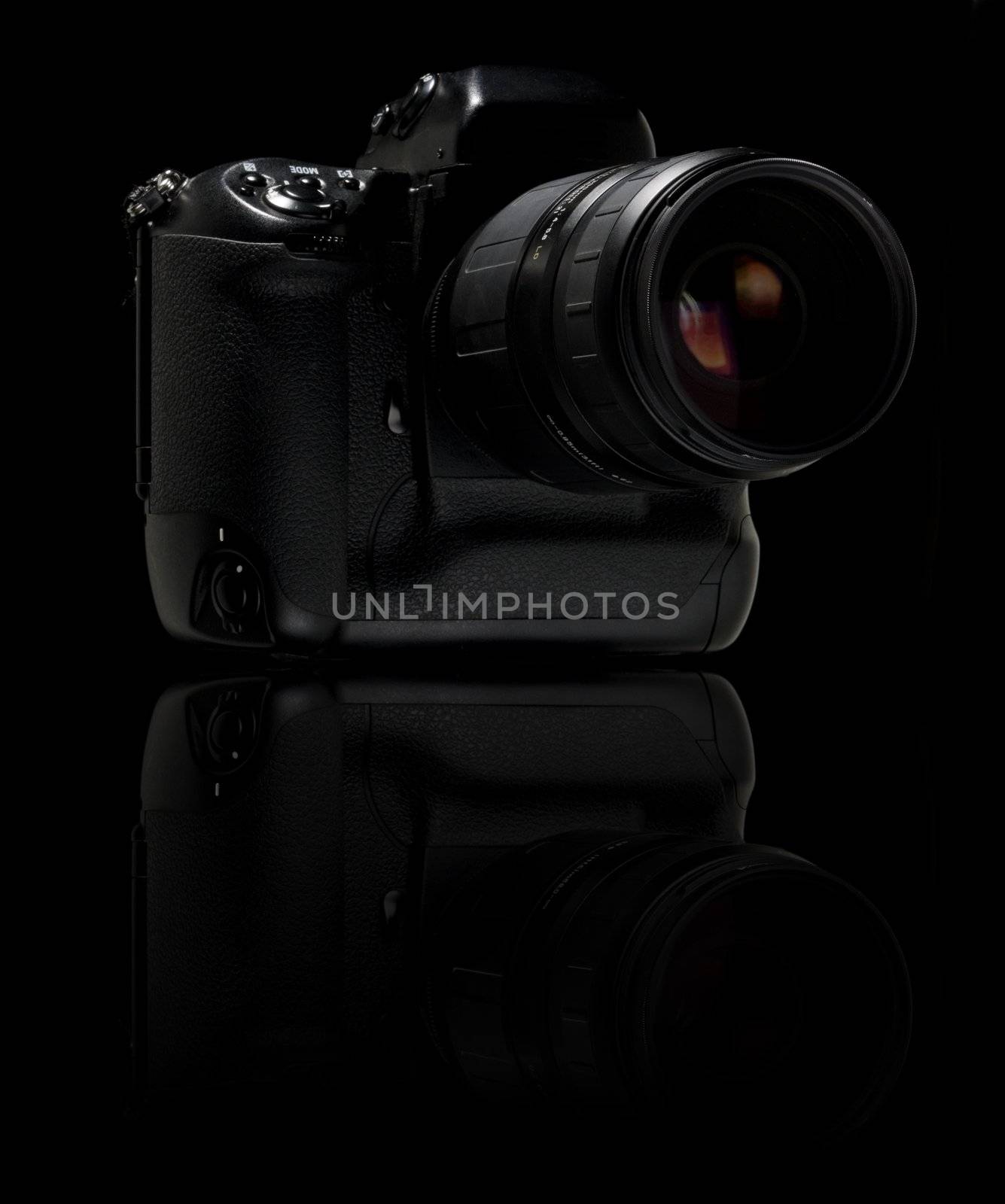 Professional digital camera over black background. With reflection.